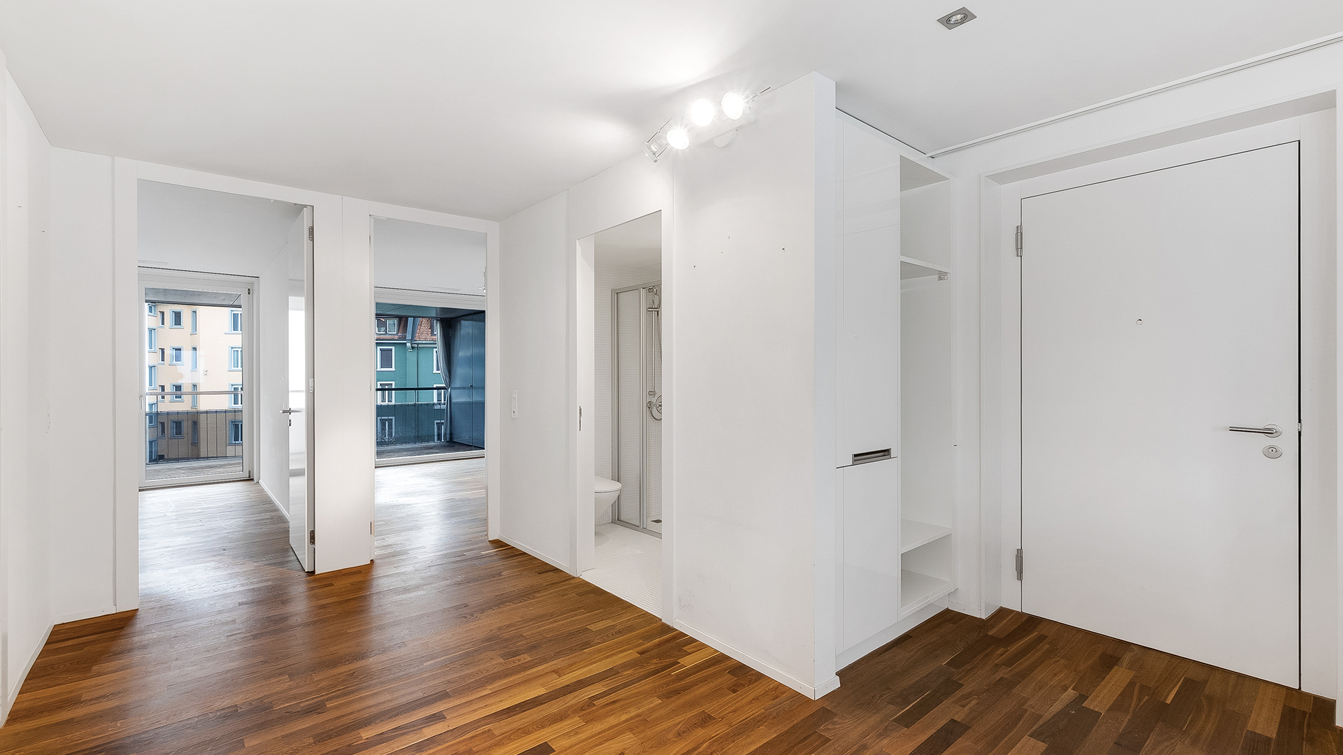 Heller Wohnungsflur mit Balkonblick und Badzugang
