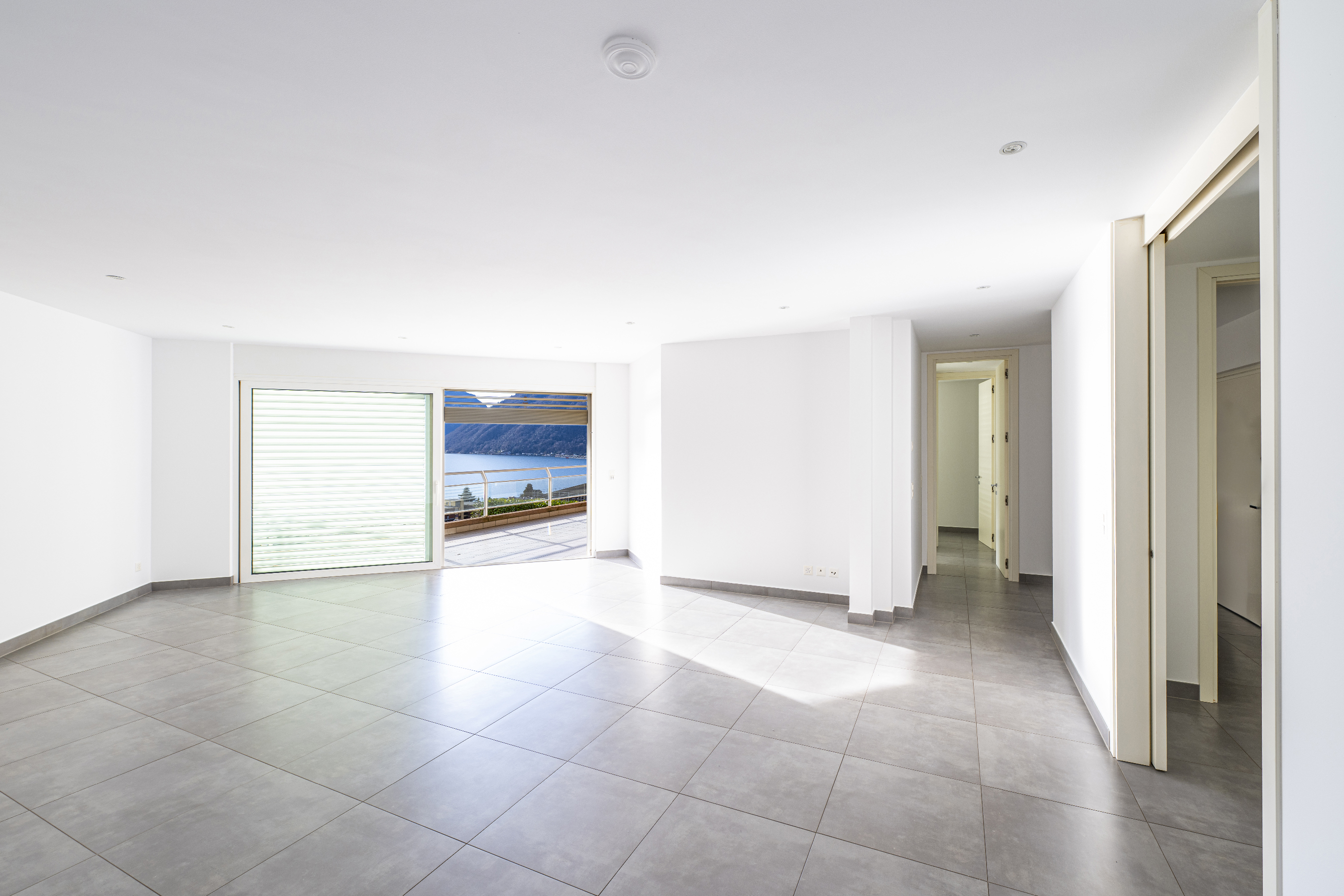 Heller, leerer Wohnraum mit Terrasse und Meerblick