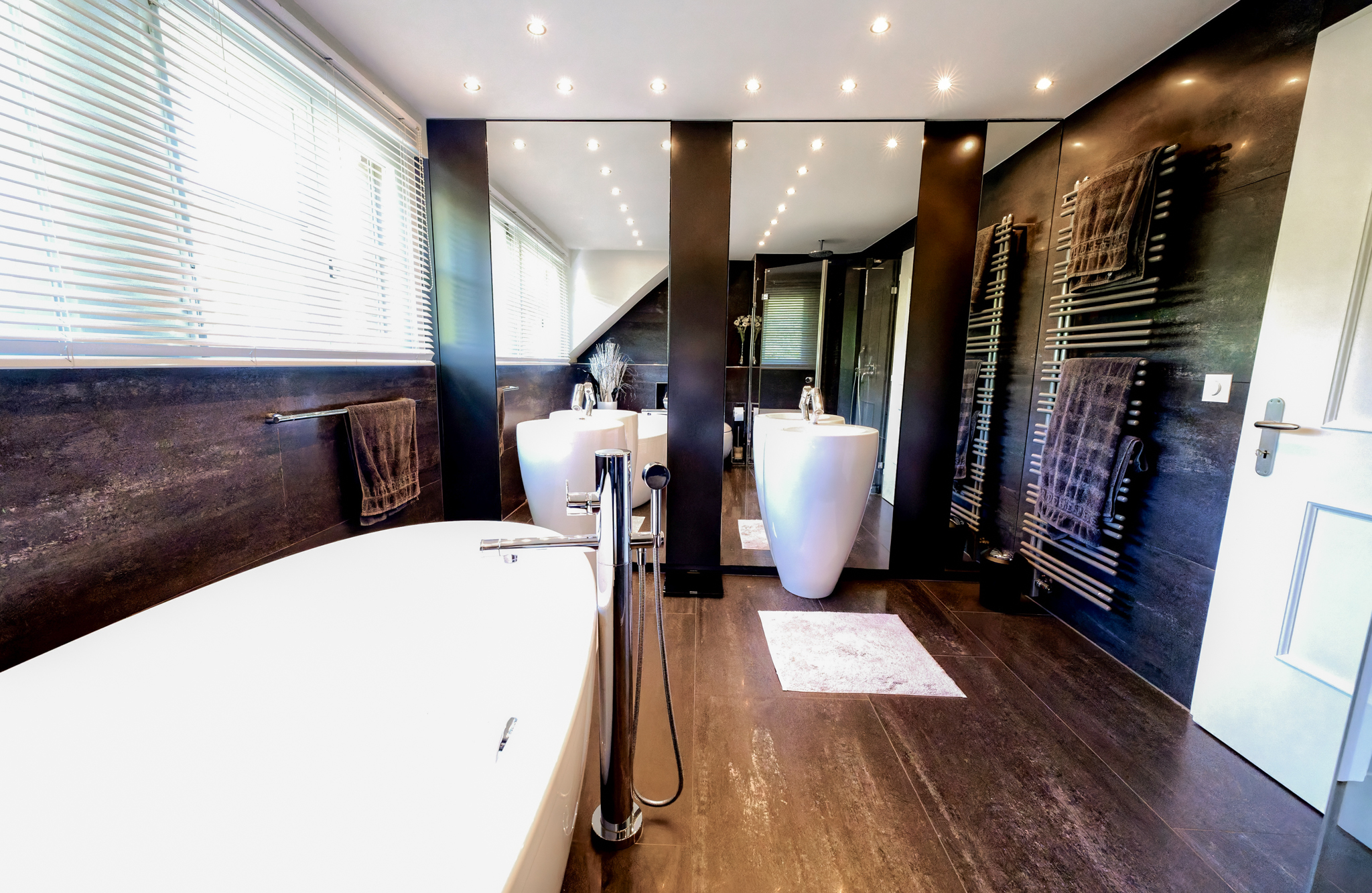 Modernes Badezimmer mit freistehender Wanne und großen Spiegeln