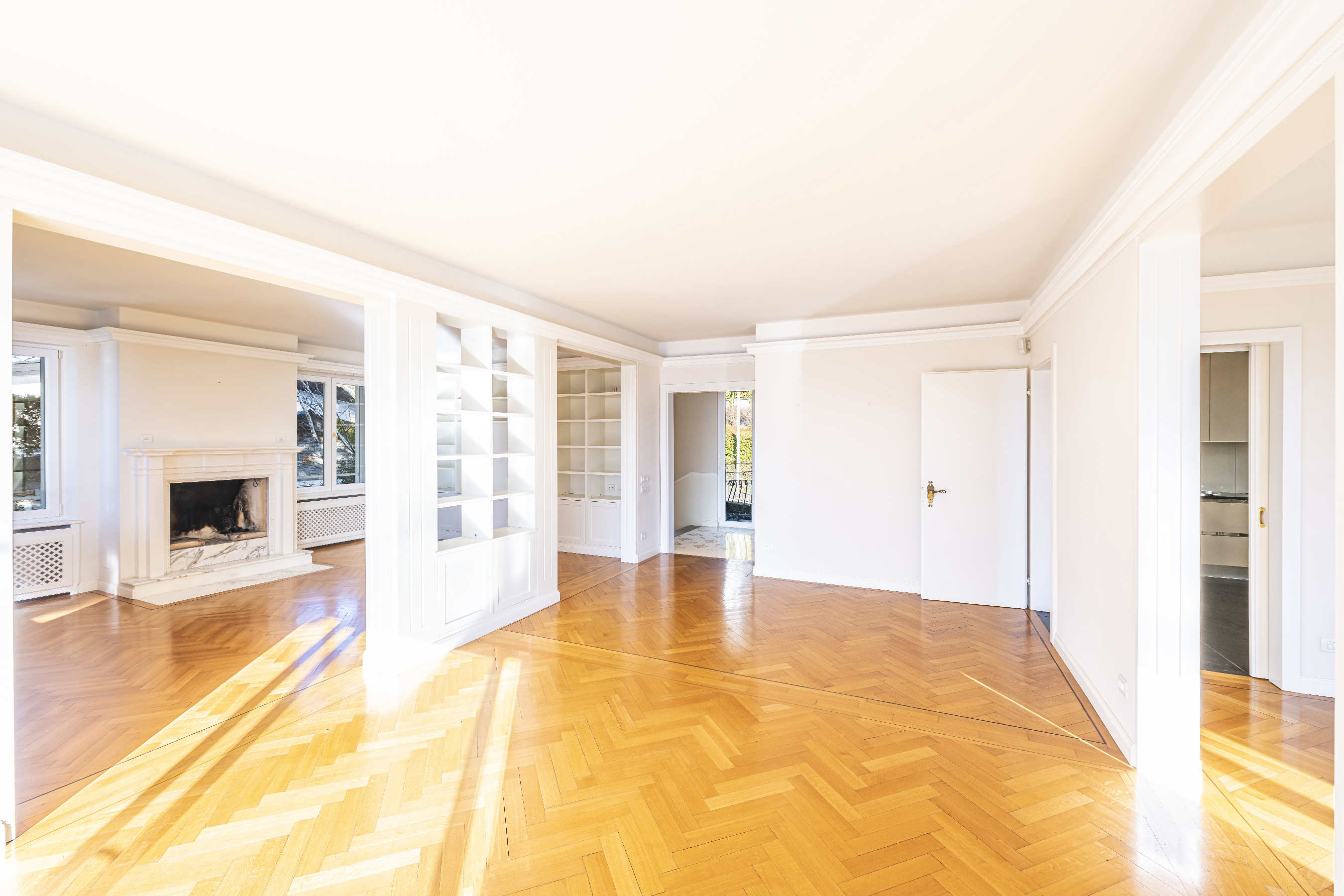 Heller leerer Wohnraum mit Kamin und Parkettboden