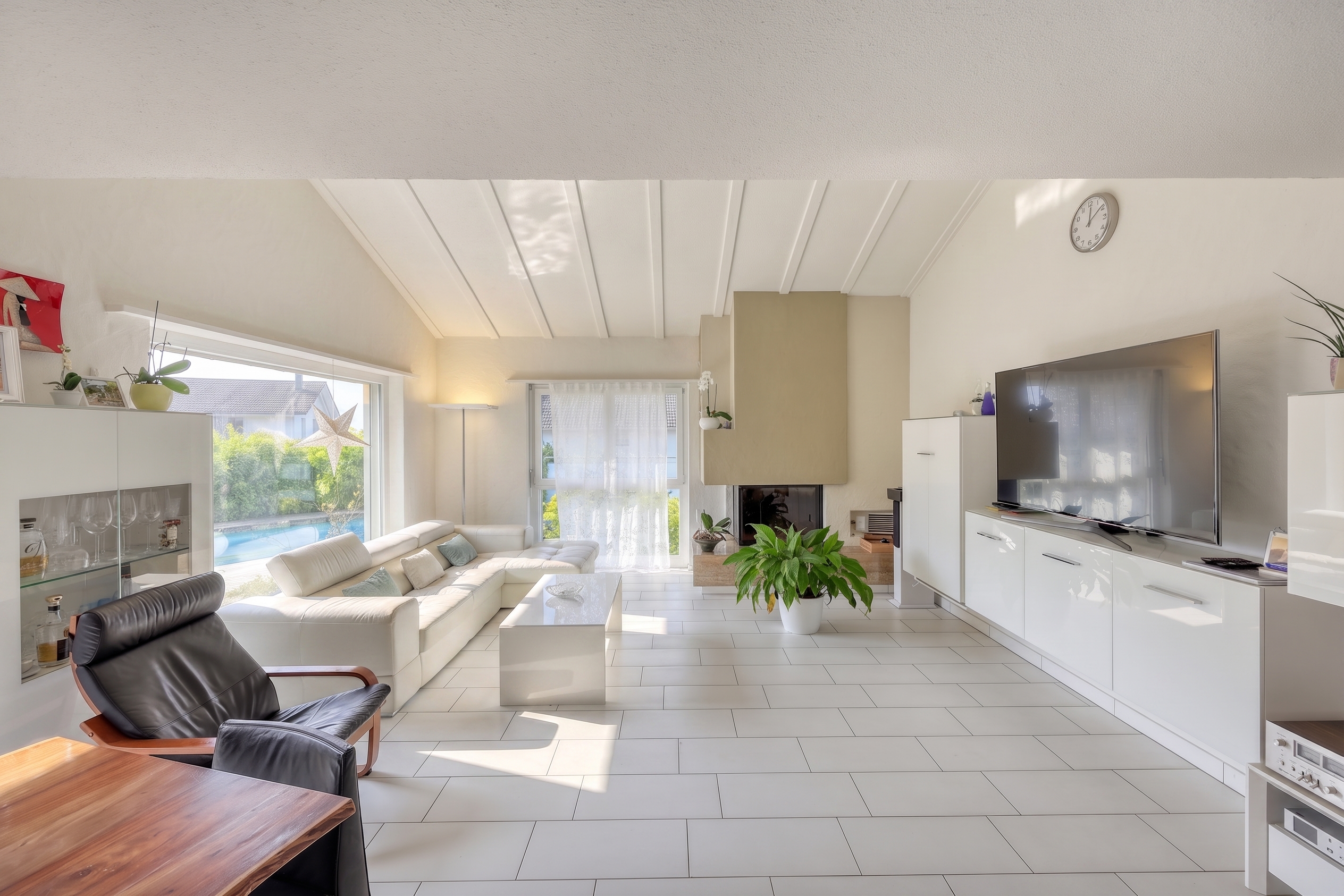 Helles Wohnzimmer mit Garten- und Poolblick