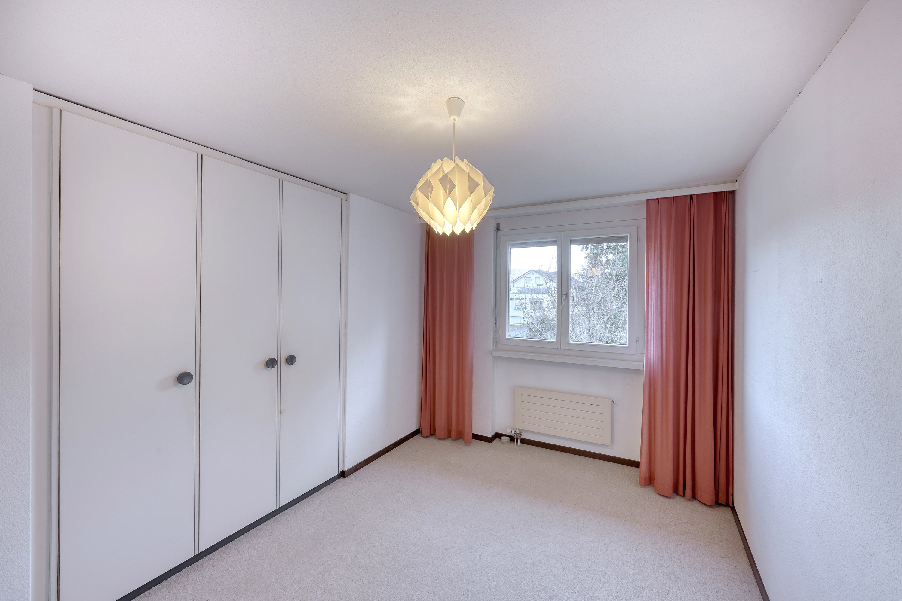 Helles Schlafzimmer mit Einbauschrank und Fenster