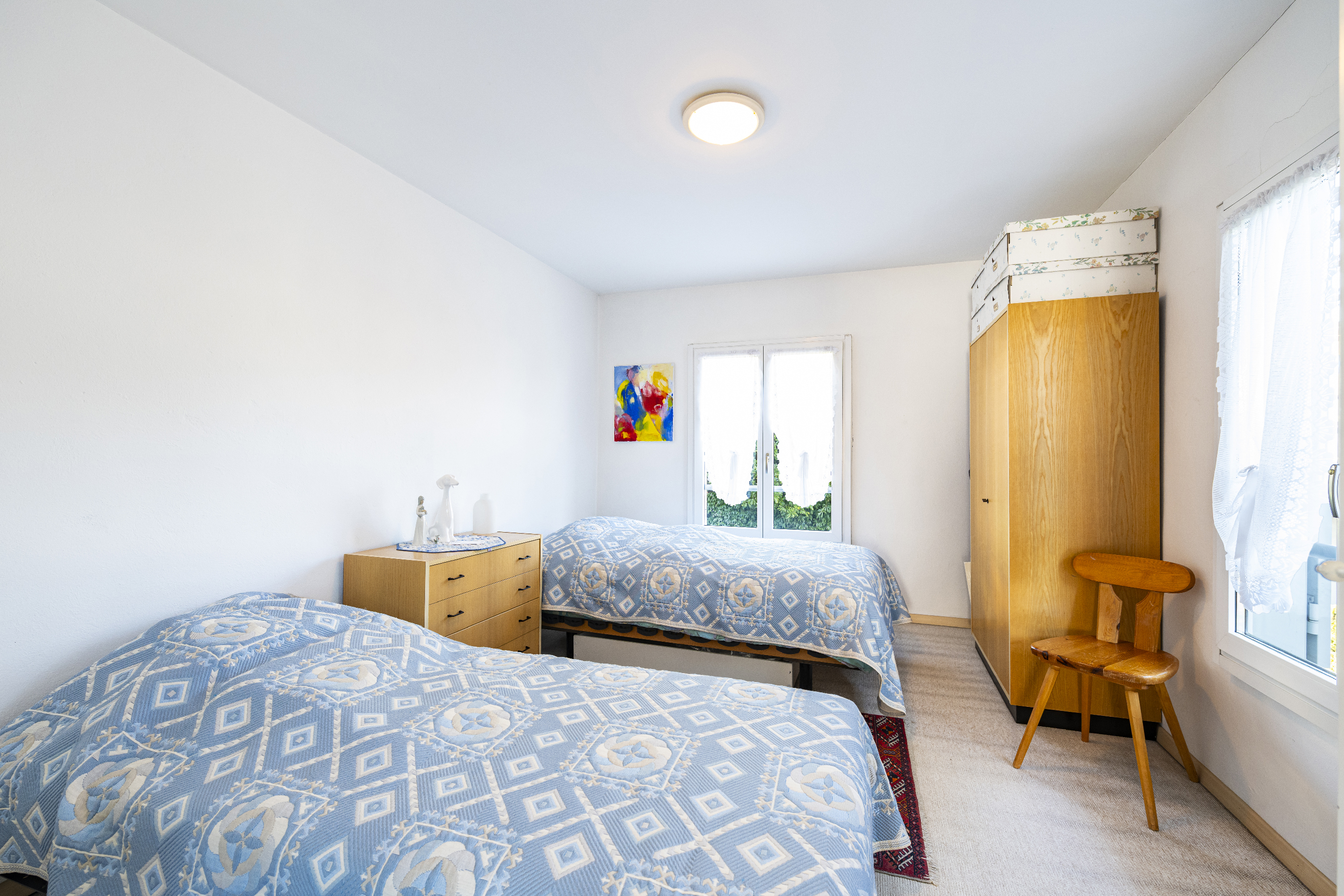 Helles Schlafzimmer mit zwei Betten und Kleiderschrank