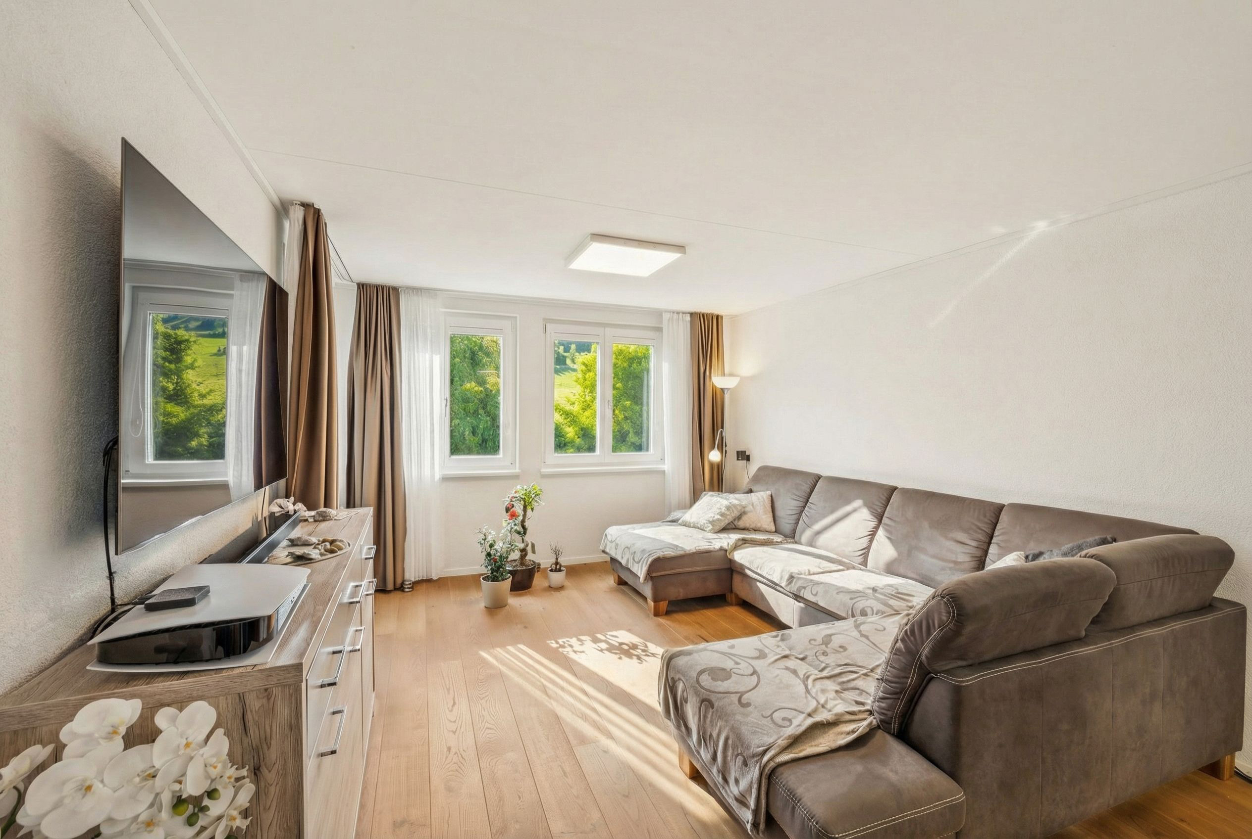 Helles Wohnzimmer mit Ecksofa und Gartenblick