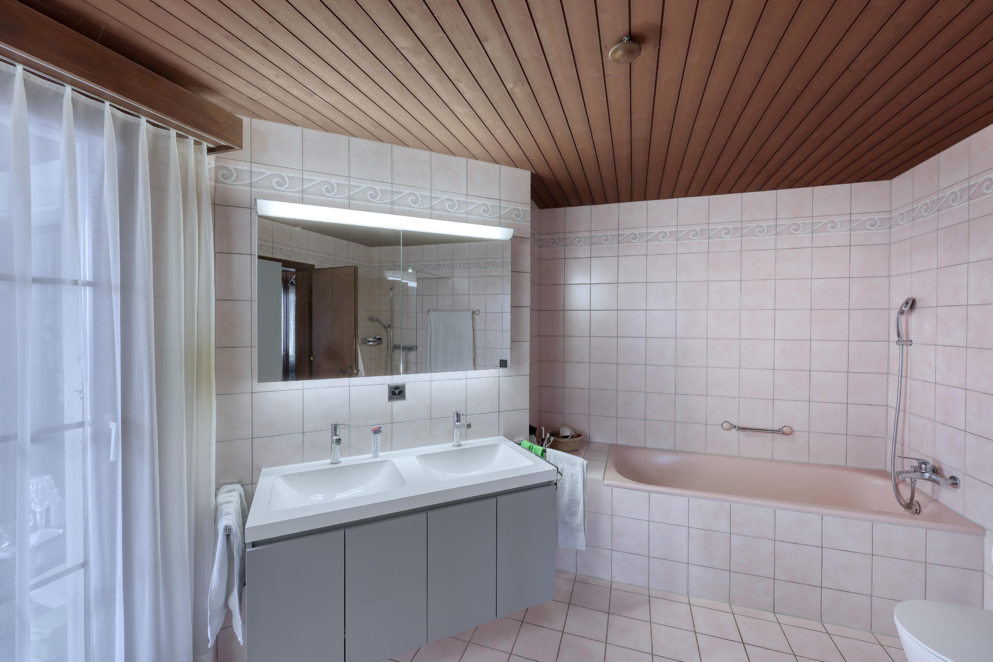 Badezimmer mit Badewanne und Doppelwaschtisch