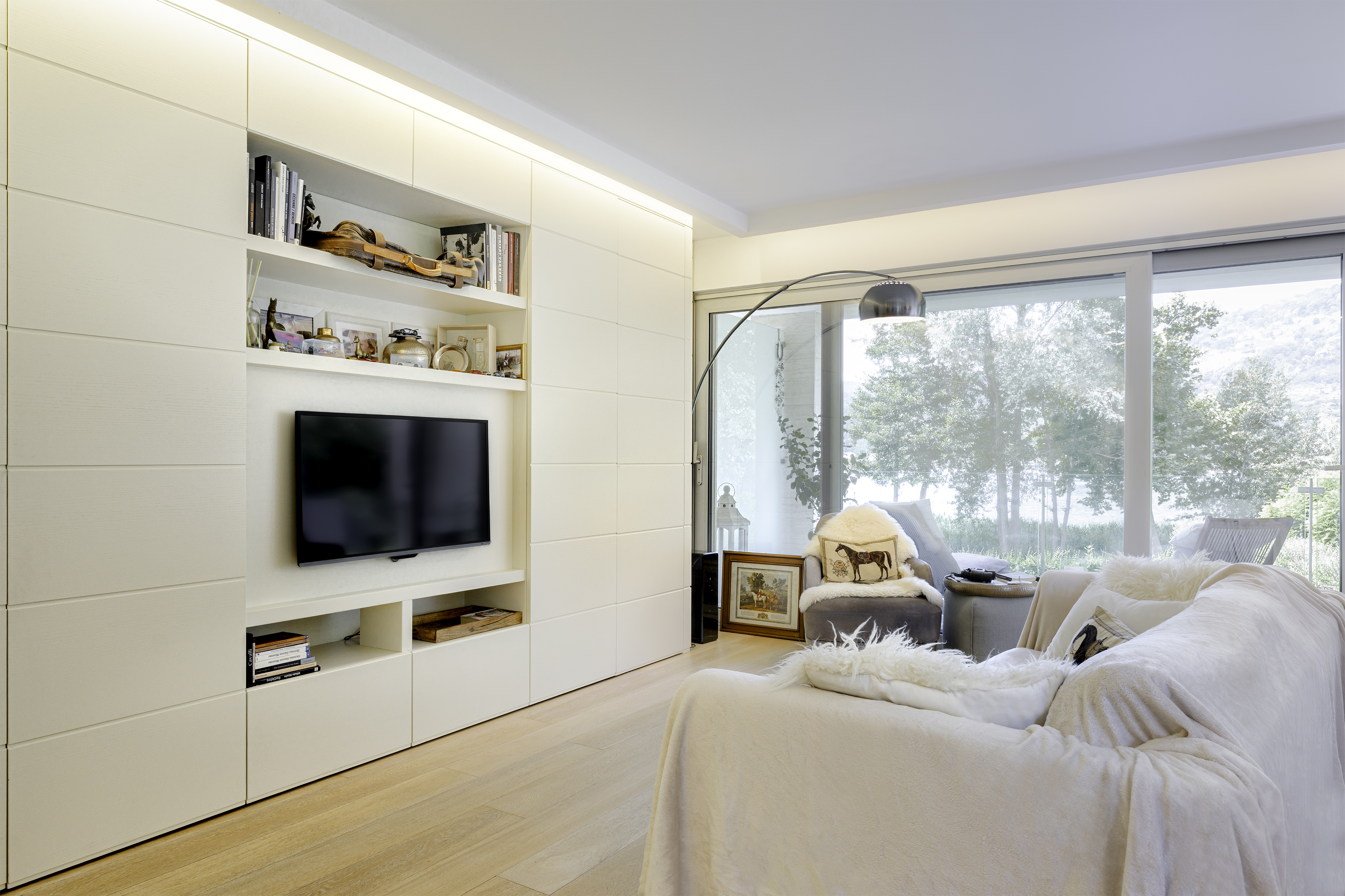 Helles Wohnzimmer mit großem Fenster und Einbauschrank