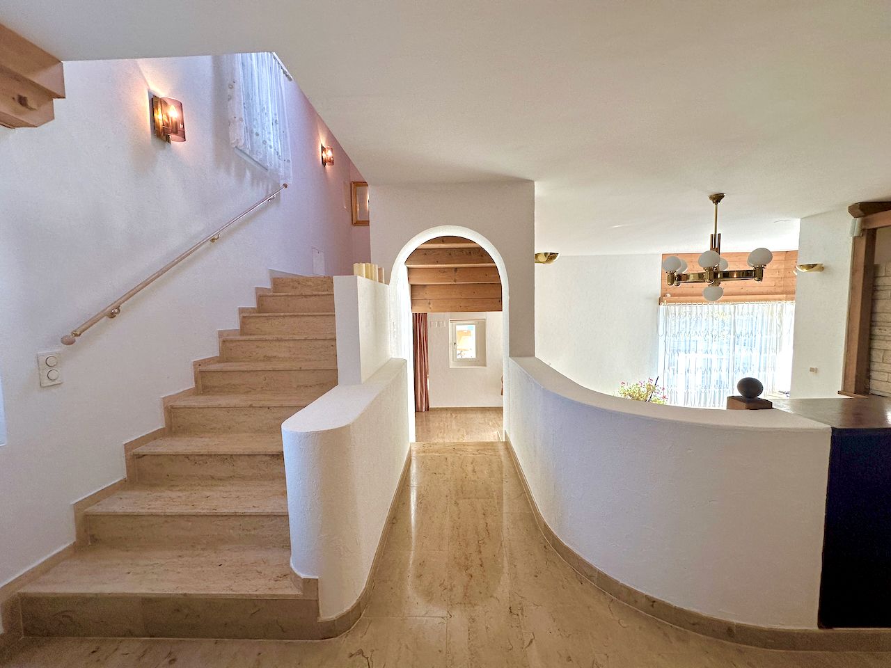 Treppe mit gewölbtem Durchgang im hellen Innenraum