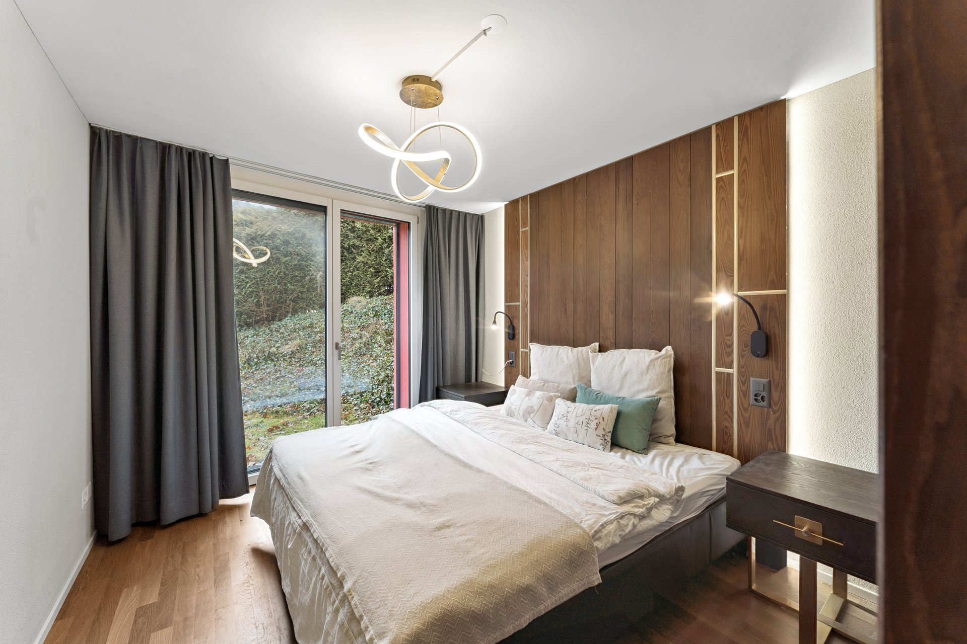 Modernes Schlafzimmer mit Balkon- oder Terrassentür und Holzakzentwand