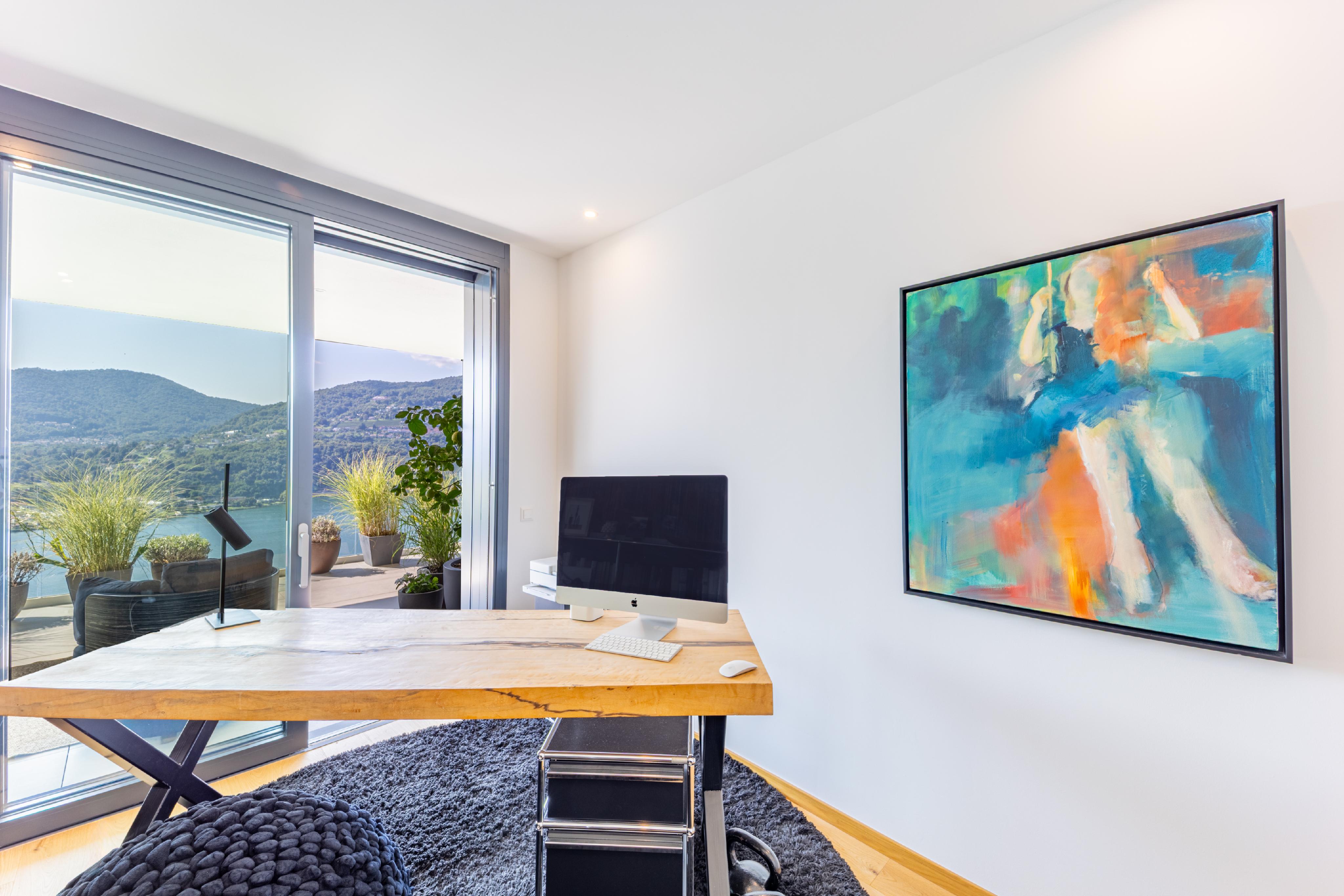 Hell eingerichtetes Arbeitszimmer mit Seeblick