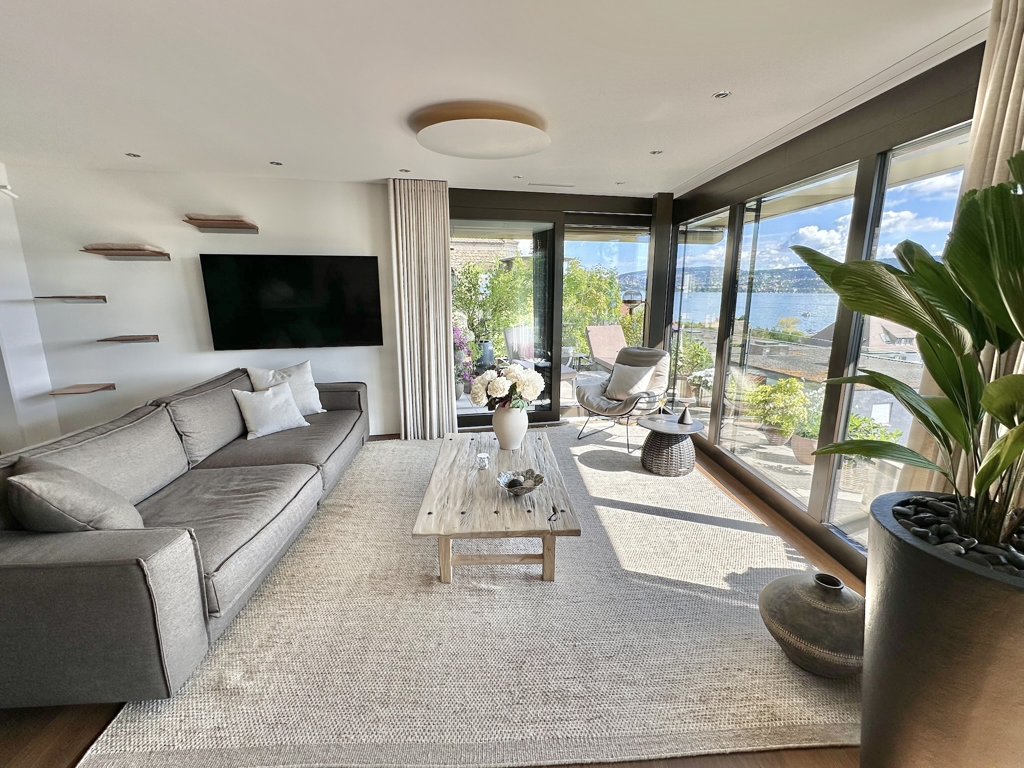 Helles, modernes Wohnzimmer mit Seeblick