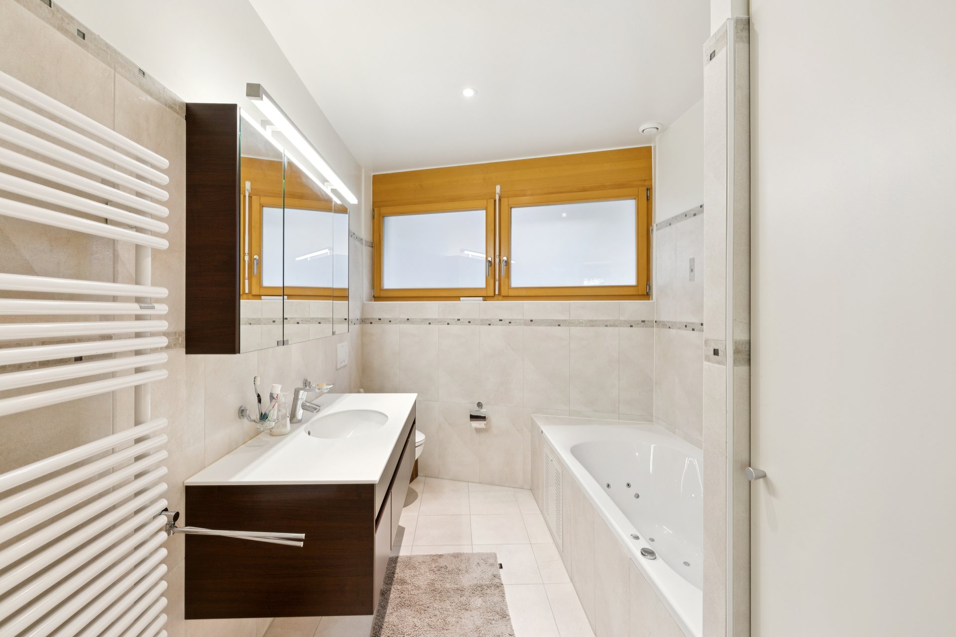 Modernes Badezimmer mit Wanne und Holzfenster