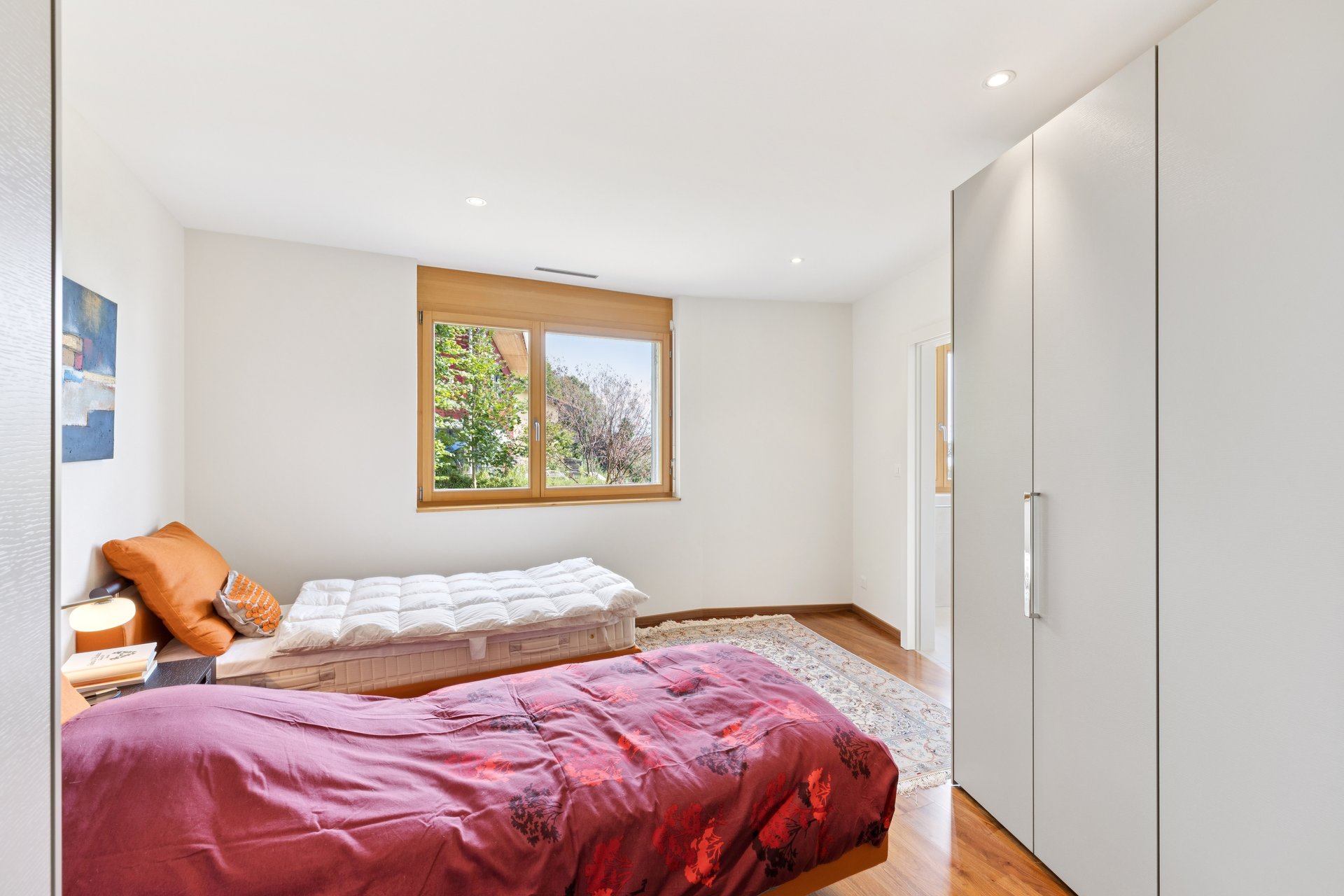 Helles Schlafzimmer mit zwei Betten und Kleiderschrank