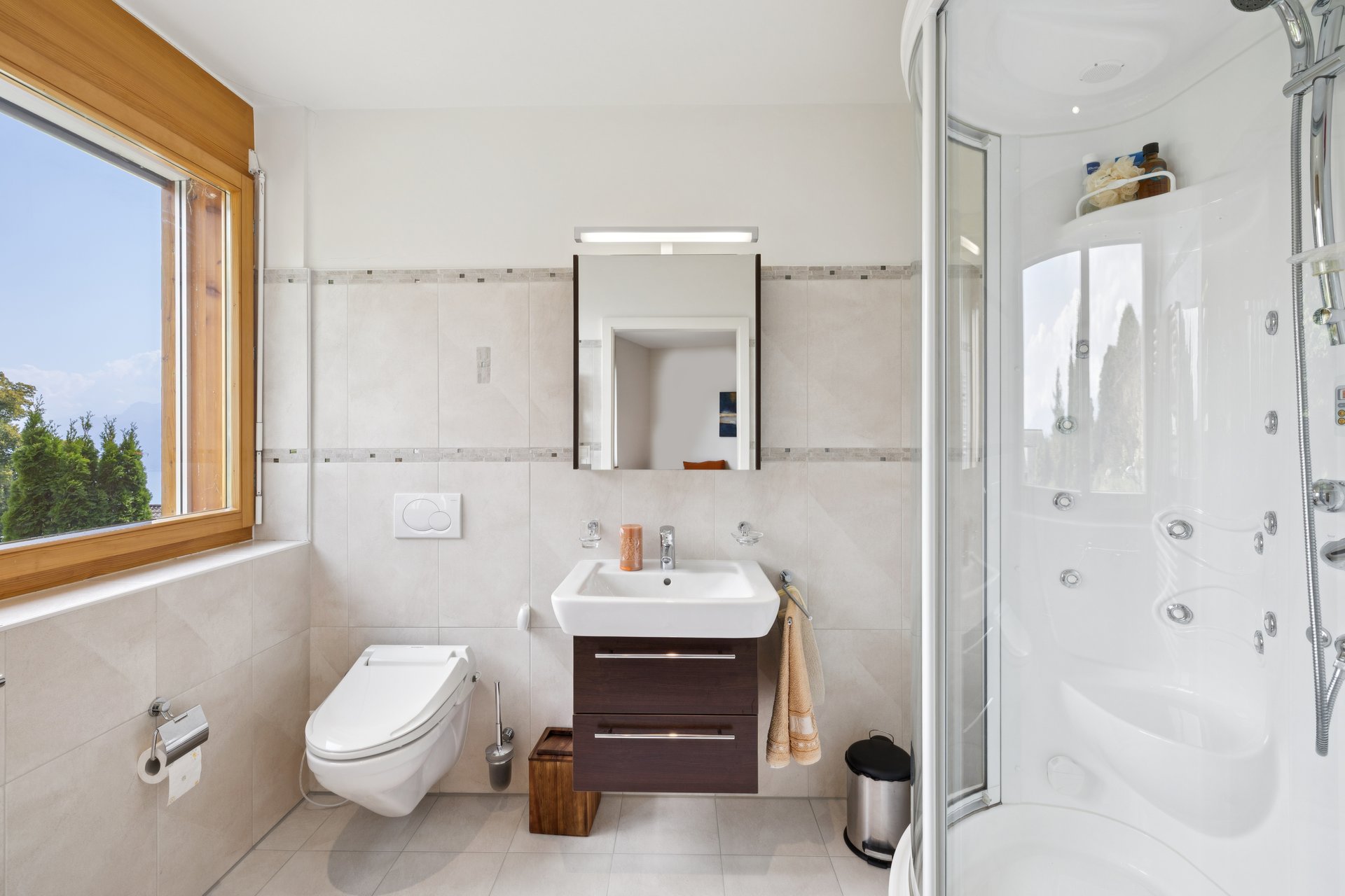Helles Badezimmer mit Dusche, WC und Fenster