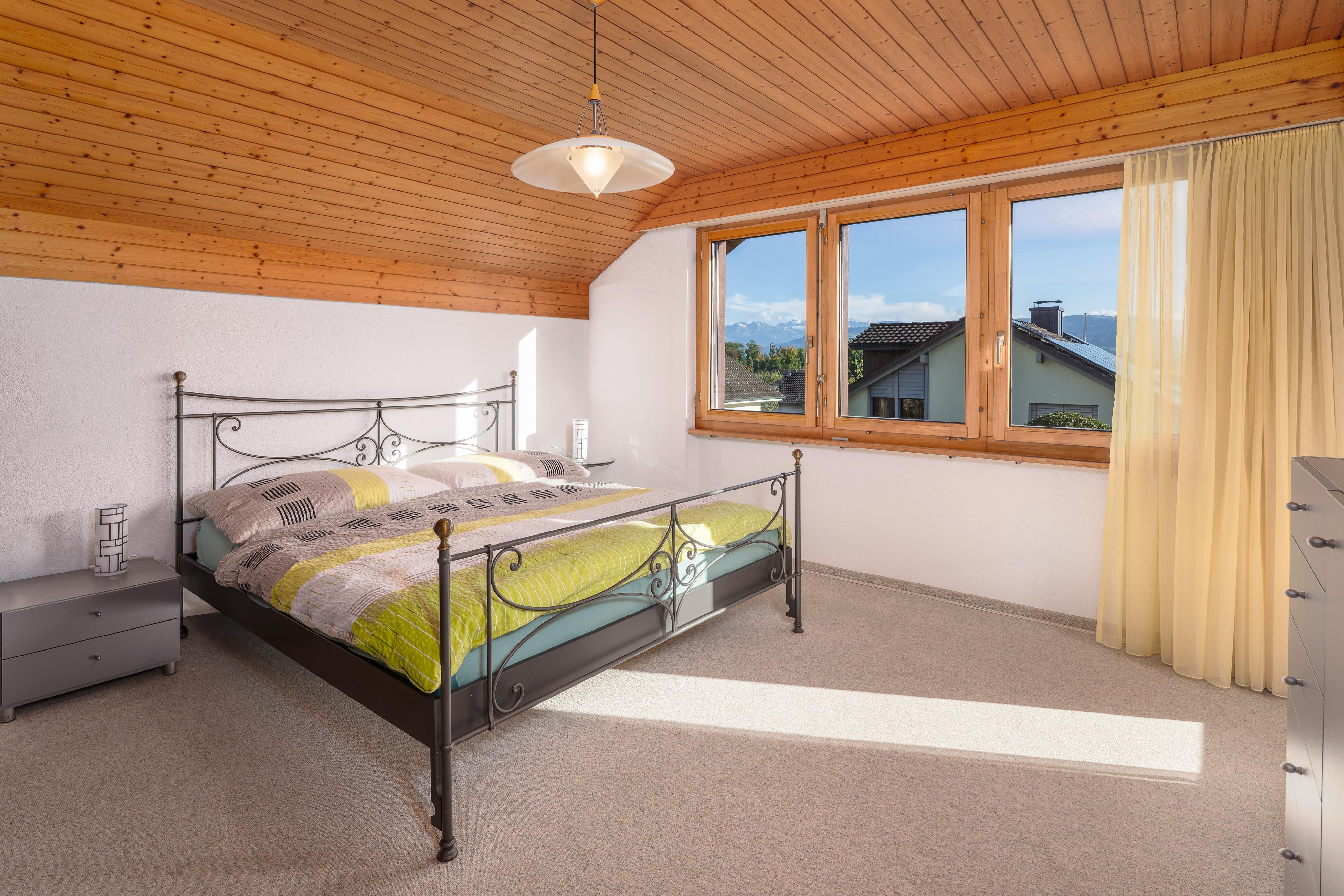 Helles Schlafzimmer mit Dachschräge und Bergblick