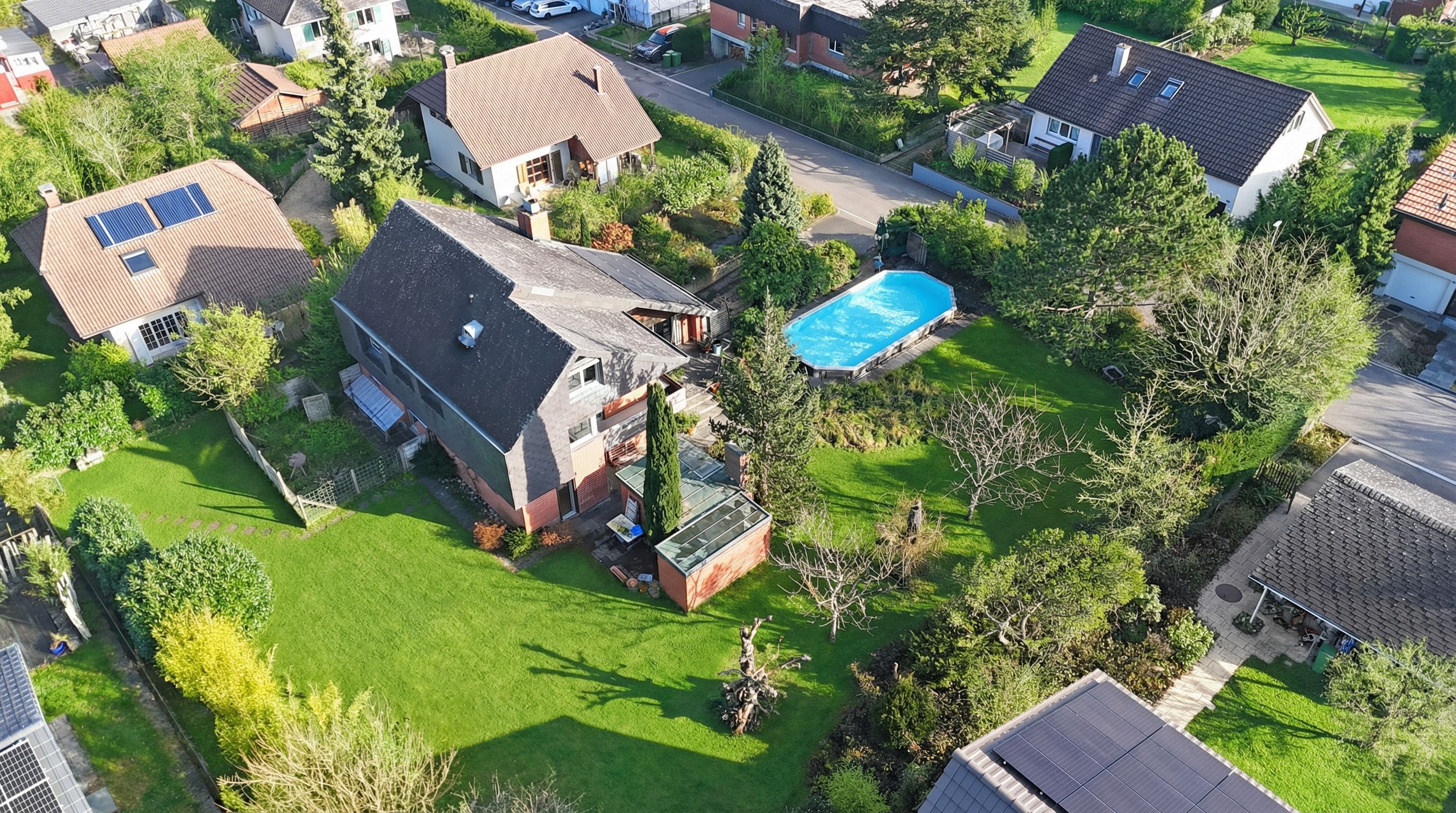 Drohnenaufnahme eines Wohnviertels mit Garten und Pool