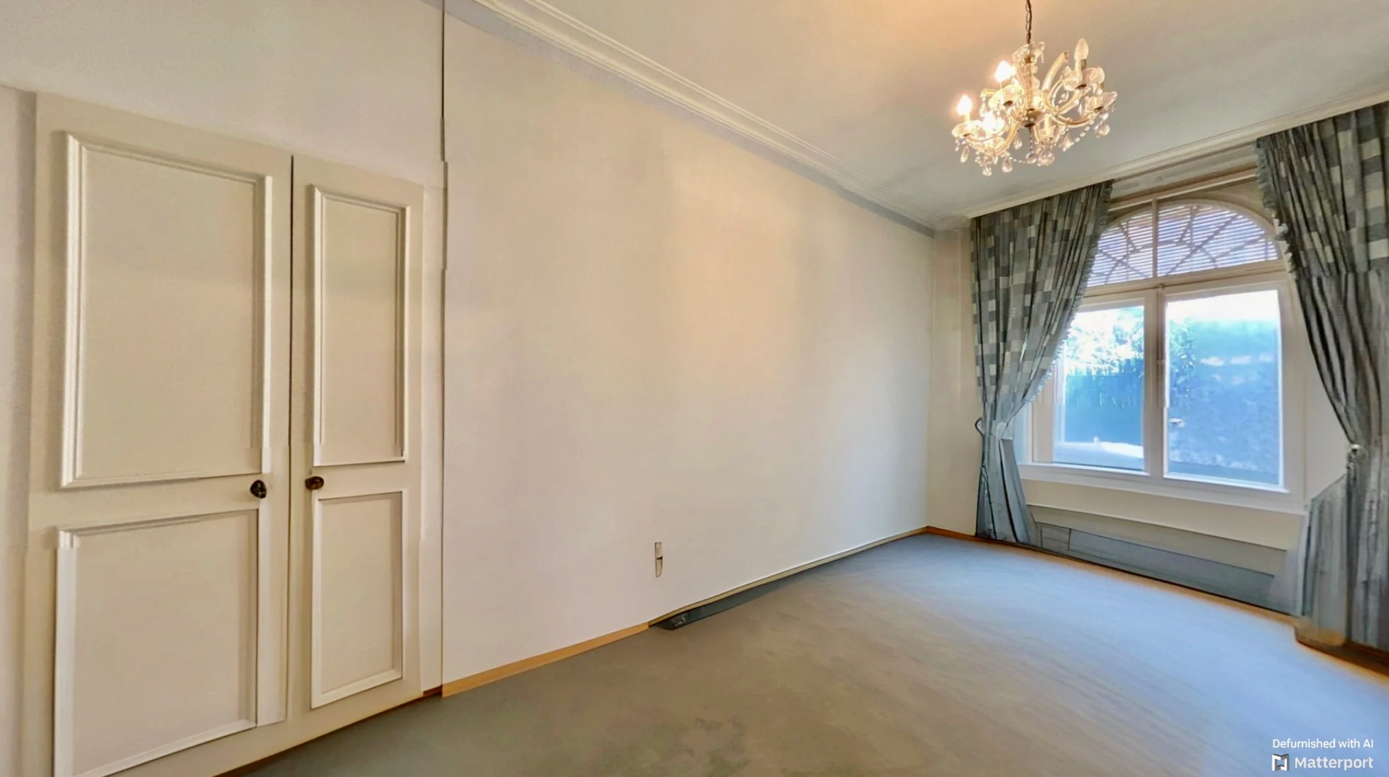 Leeres, klassisch geschnittenes Zimmer mit Kronleuchter und Erkerfenster