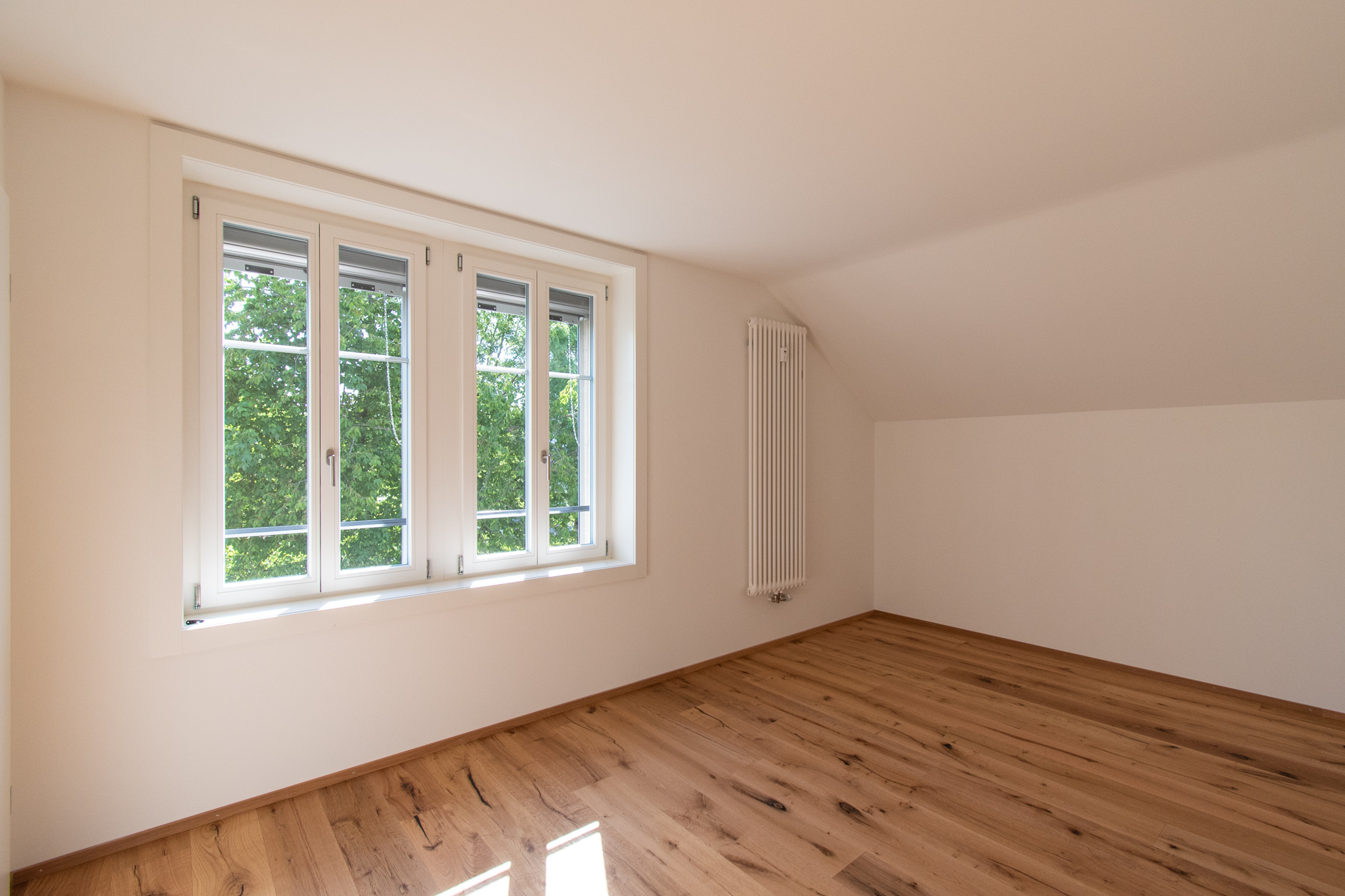 Heller leerer Dachraum mit Fenster und Heizkörper