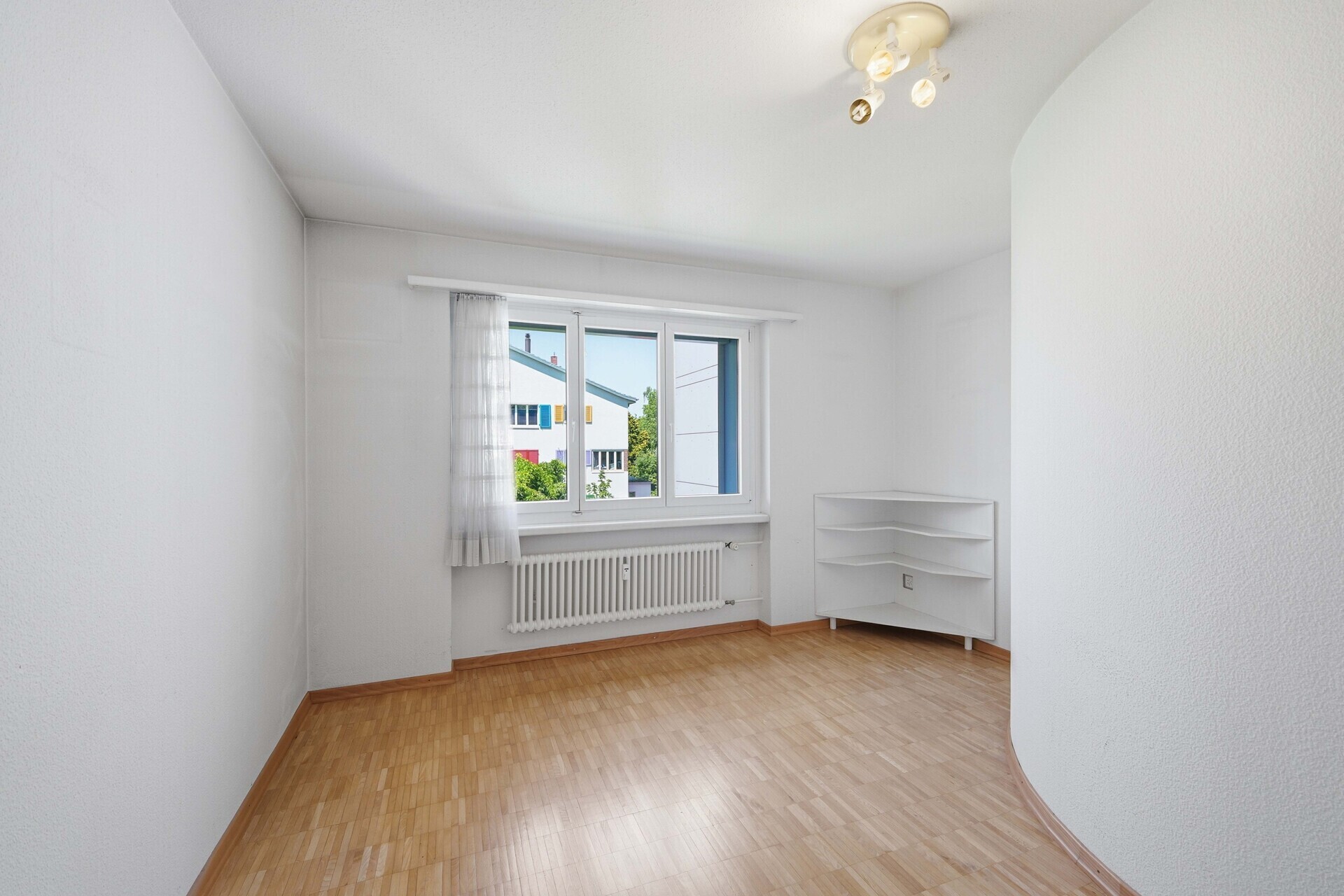 Helles, leeres Zimmer mit Fenster und Heizkörper