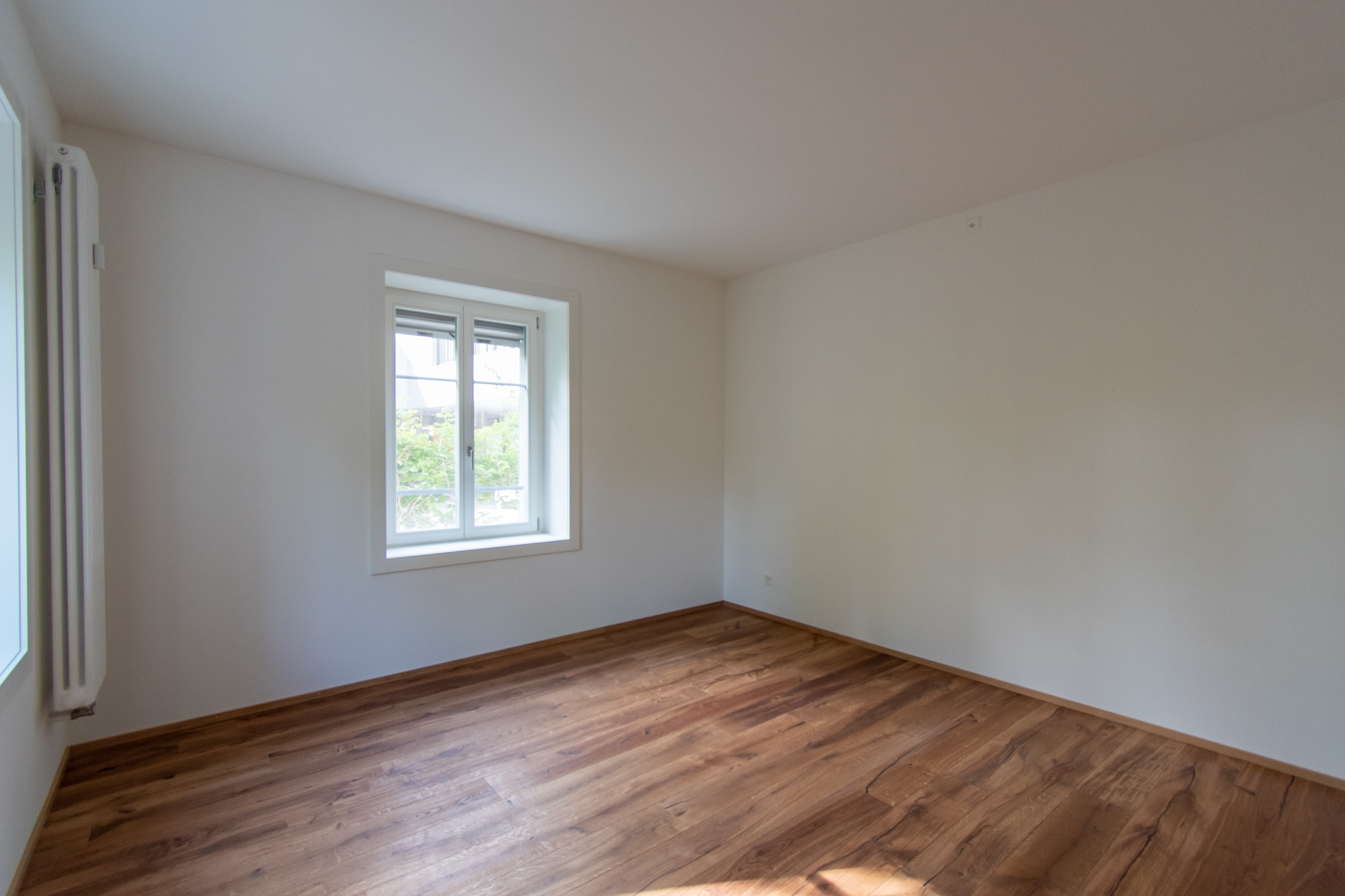 Leerer, heller Raum mit Holzboden