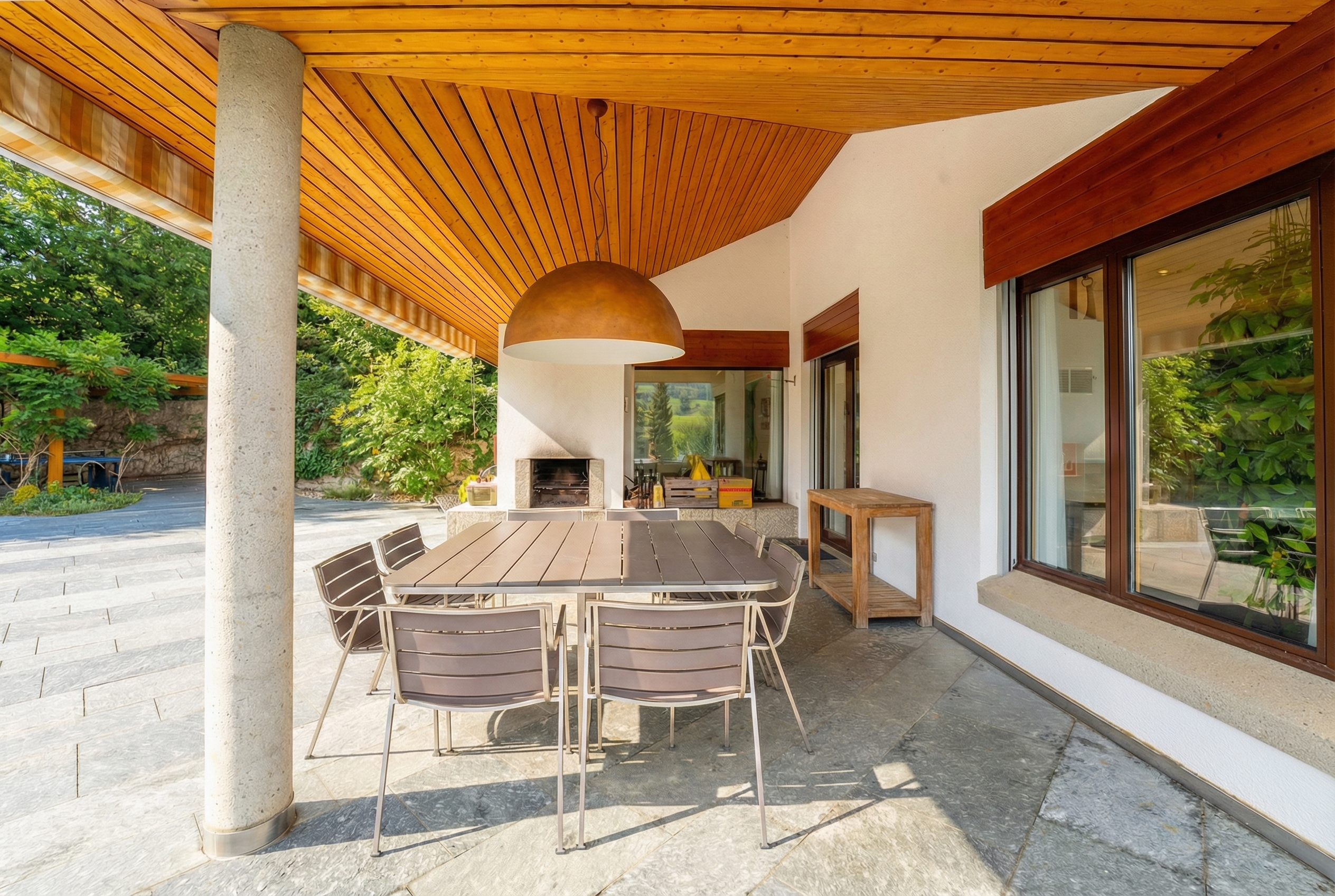 Überdachte Terrasse mit Essbereich und Außenkamin