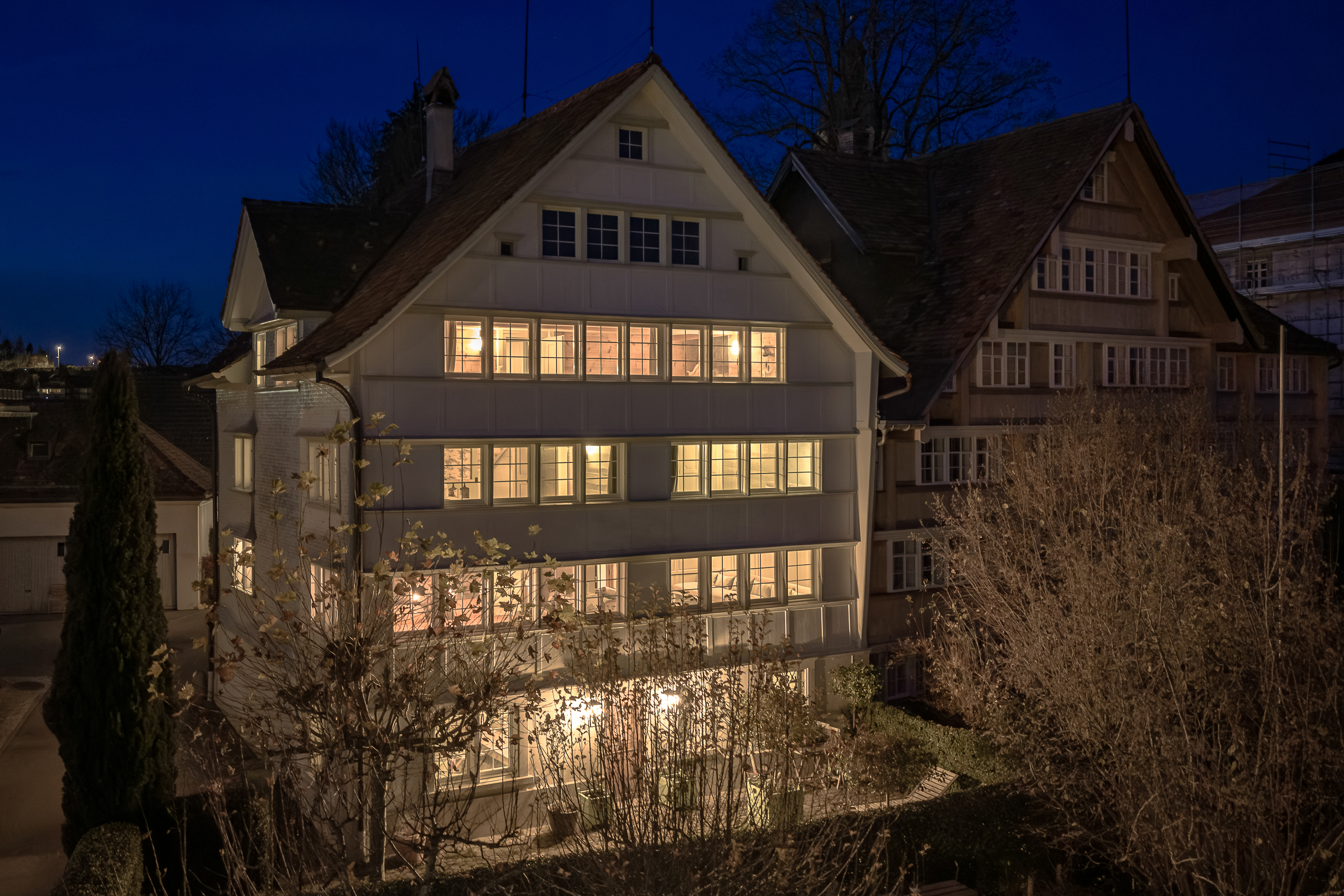 Nachtaufnahme einer historischen Wohnfassade mit steilem Giebel