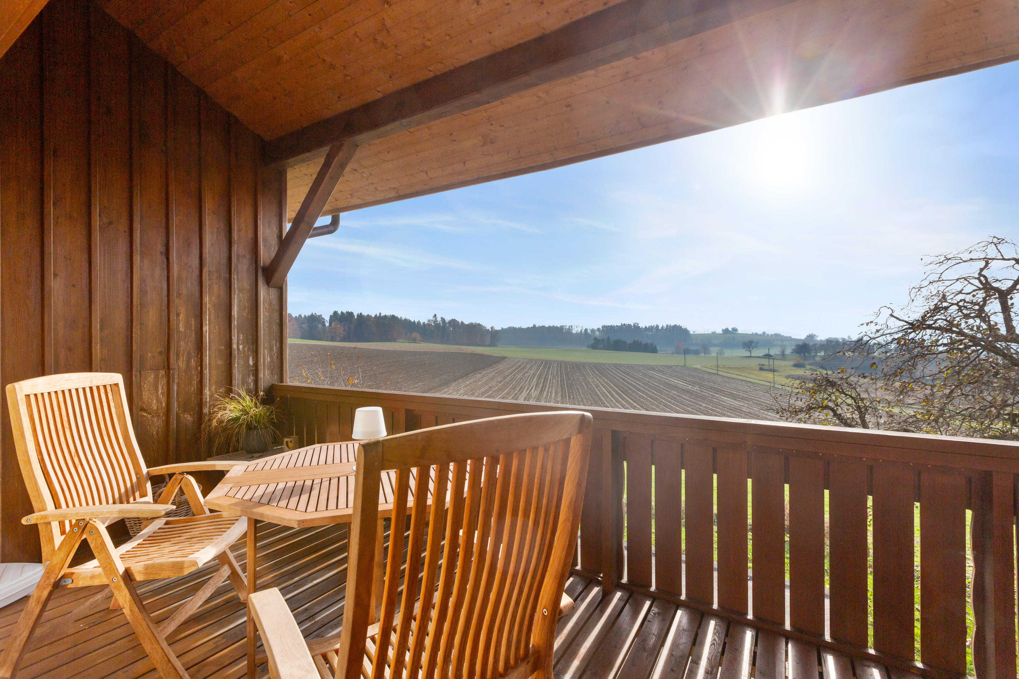 Überdachte Holzterrasse mit Landschaftsblick