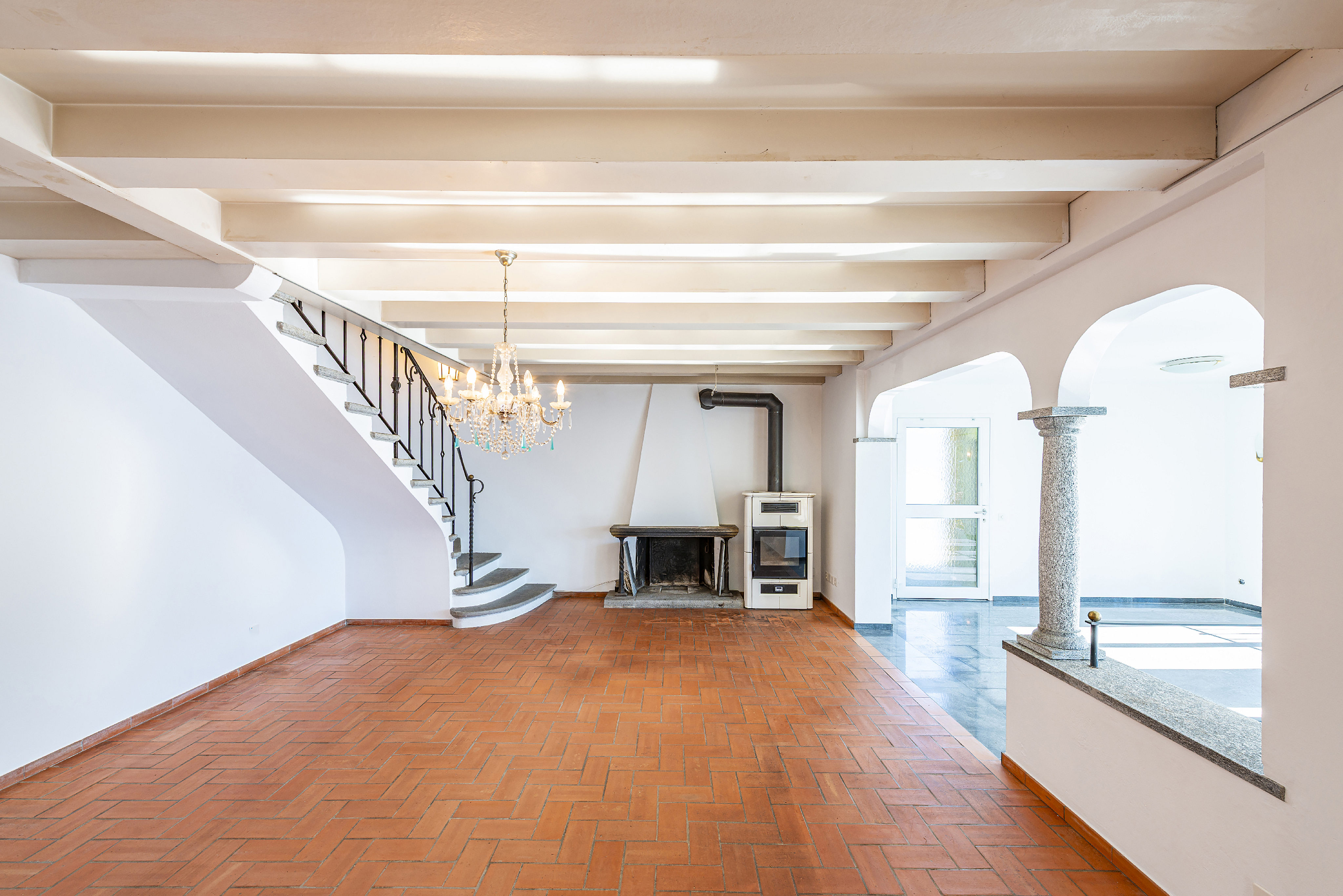 Großer Wohnraum mit Kamin und Treppe