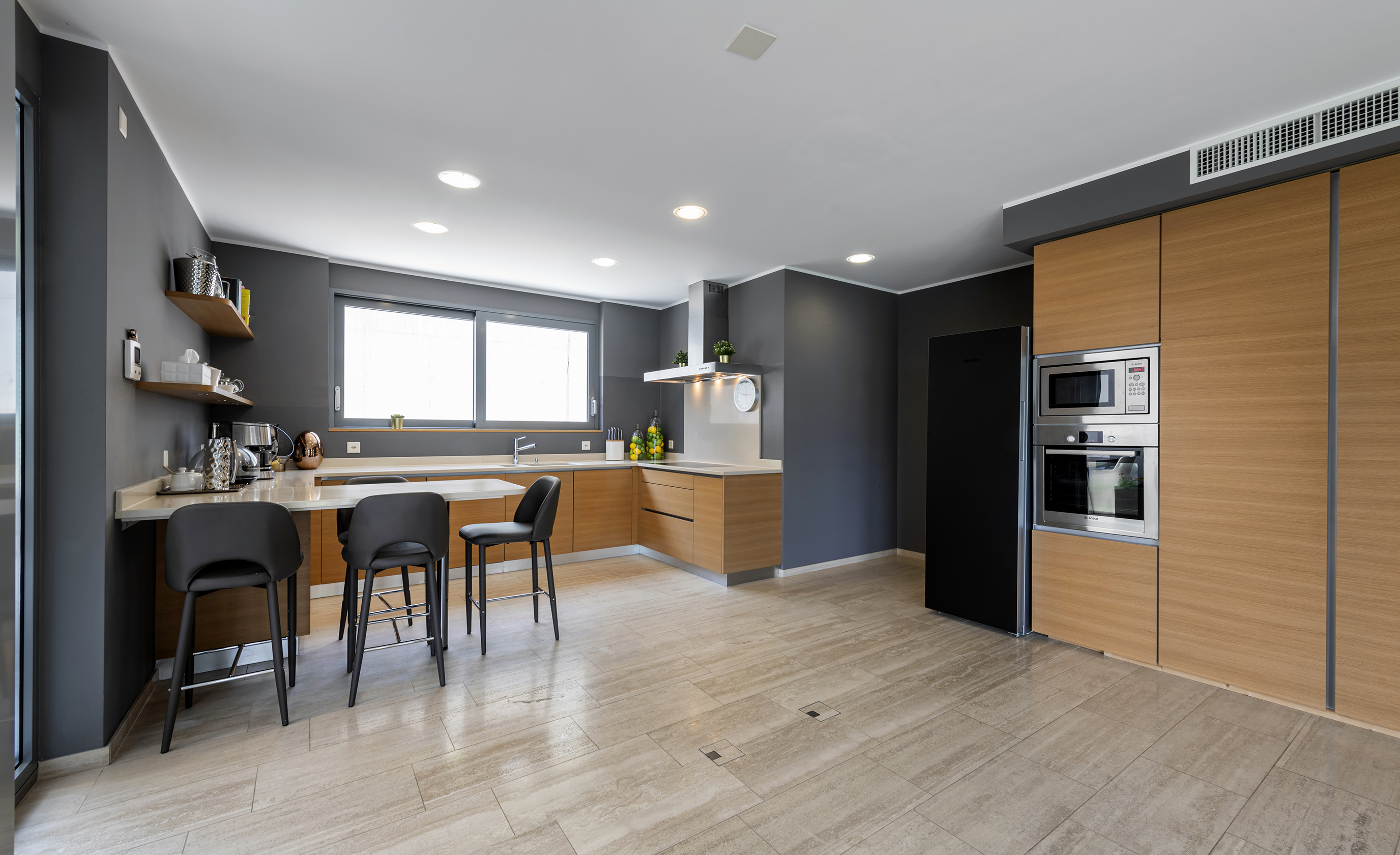 Moderne offene Küche mit dunklen Wänden und Holzfronten
