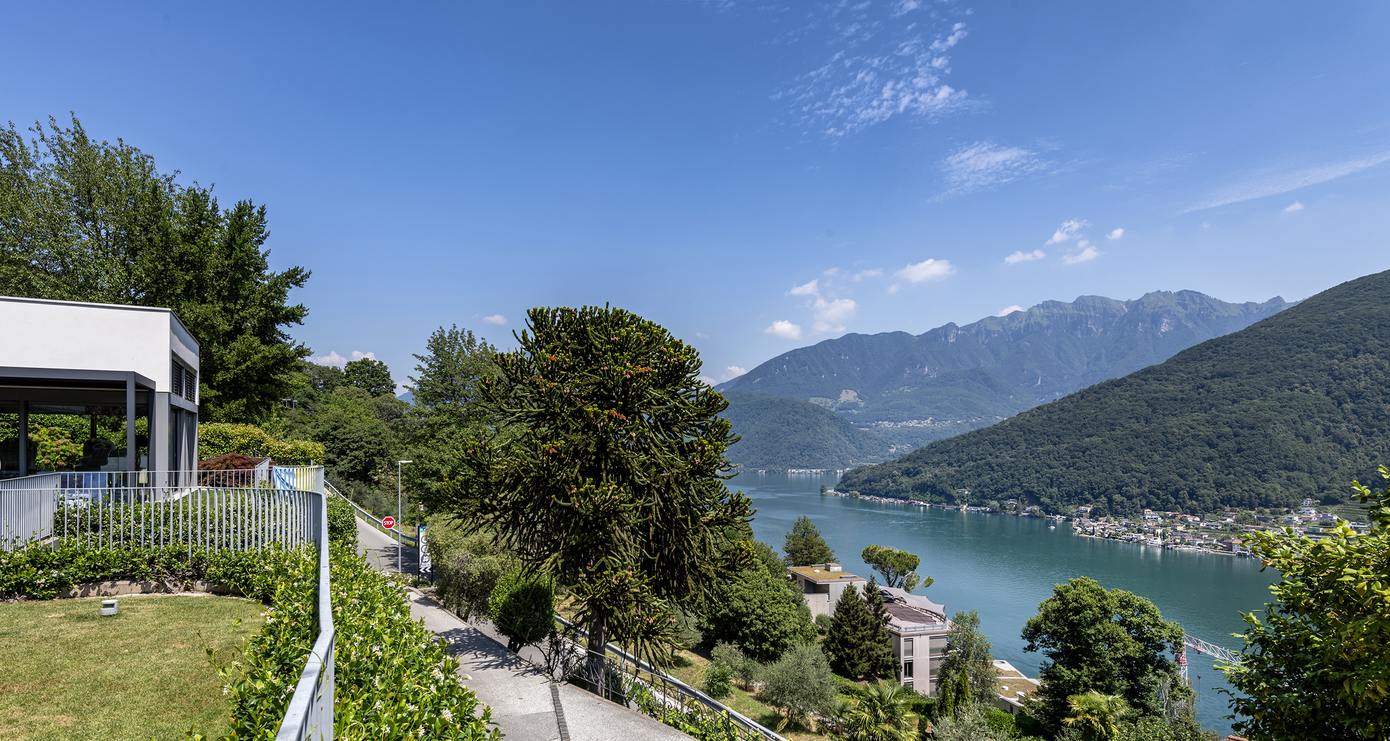 Seeblick mit moderner Villa und Bergpanorama