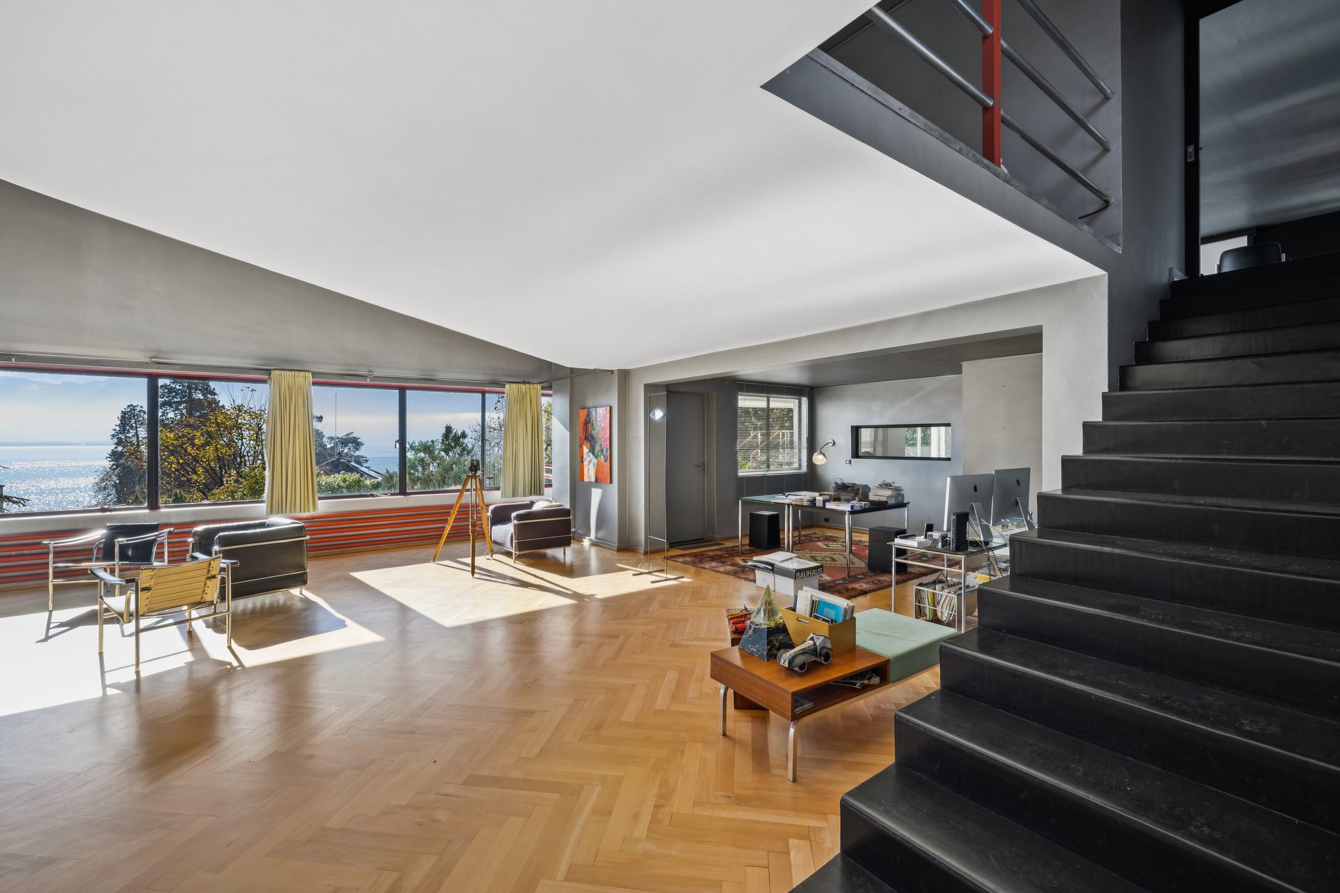 Großer moderner Wohnraum mit Treppe und Seeblick