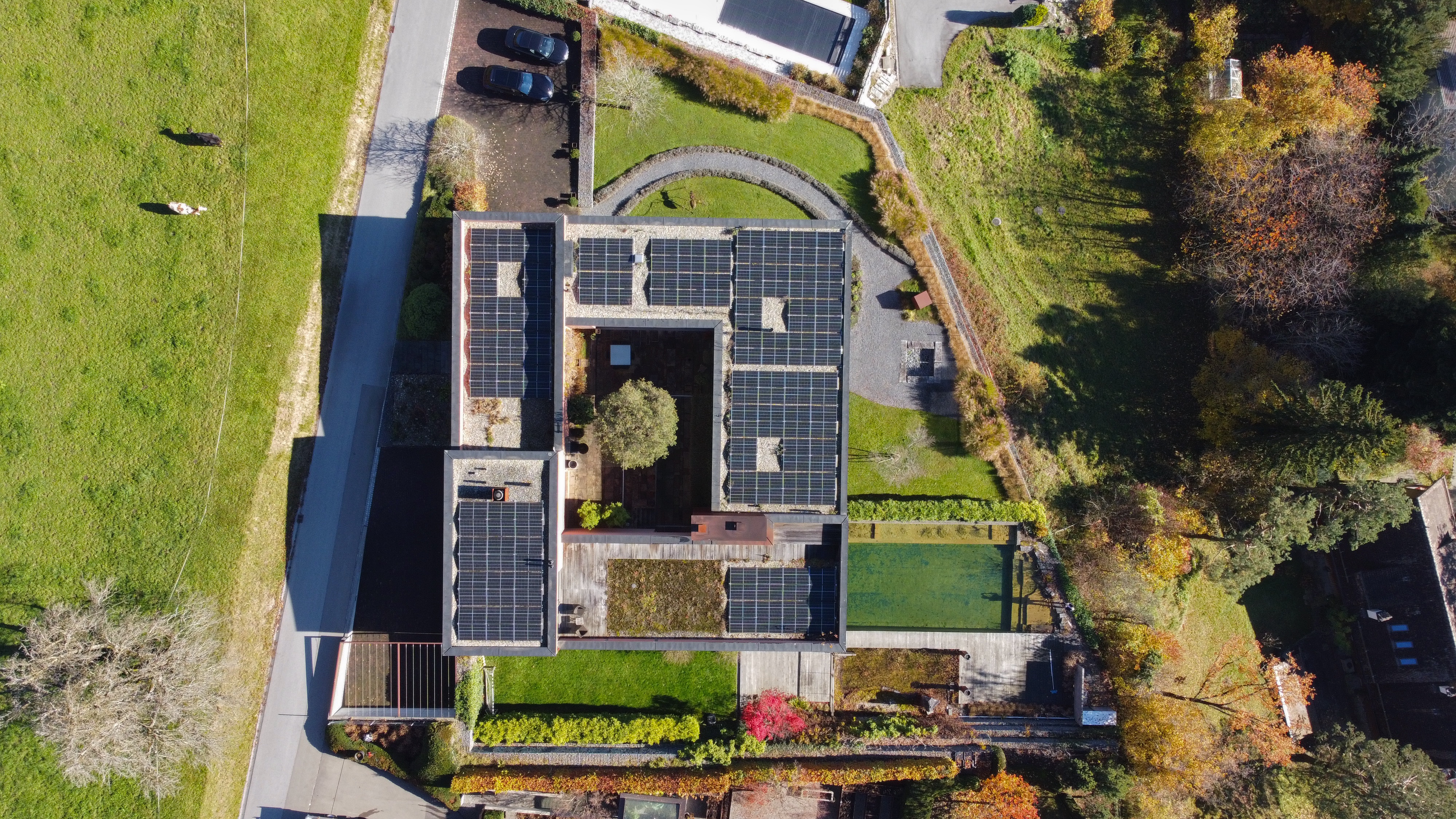 Drohnenaufnahme eines modernen Hauses mit Gründach und Solarmodulen