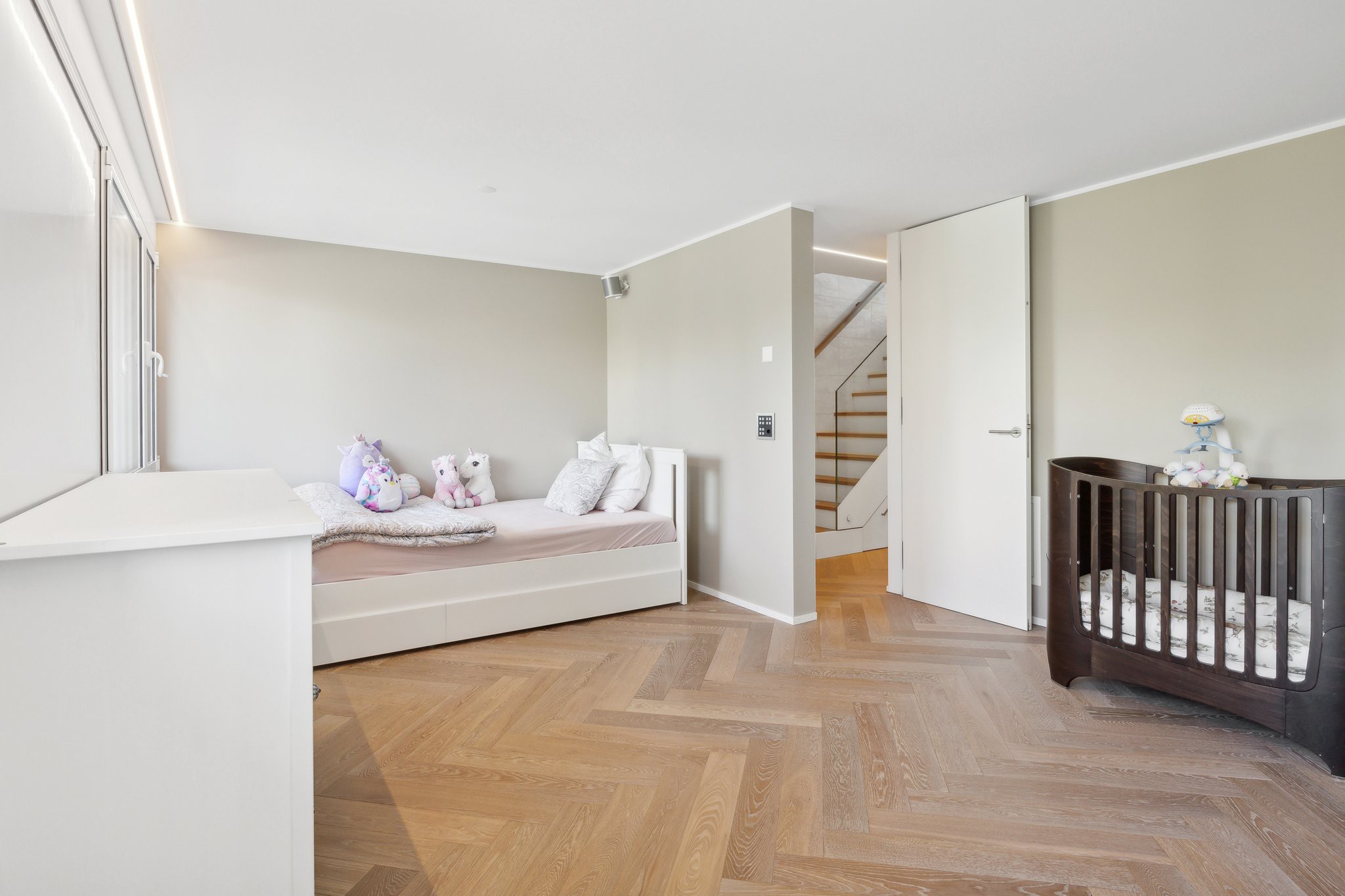 Helles Kinderzimmer mit Bett und Gitterbett