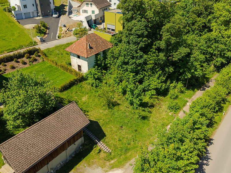 Luftaufnahme eines grünen Grundstücks mit Nebengebäuden