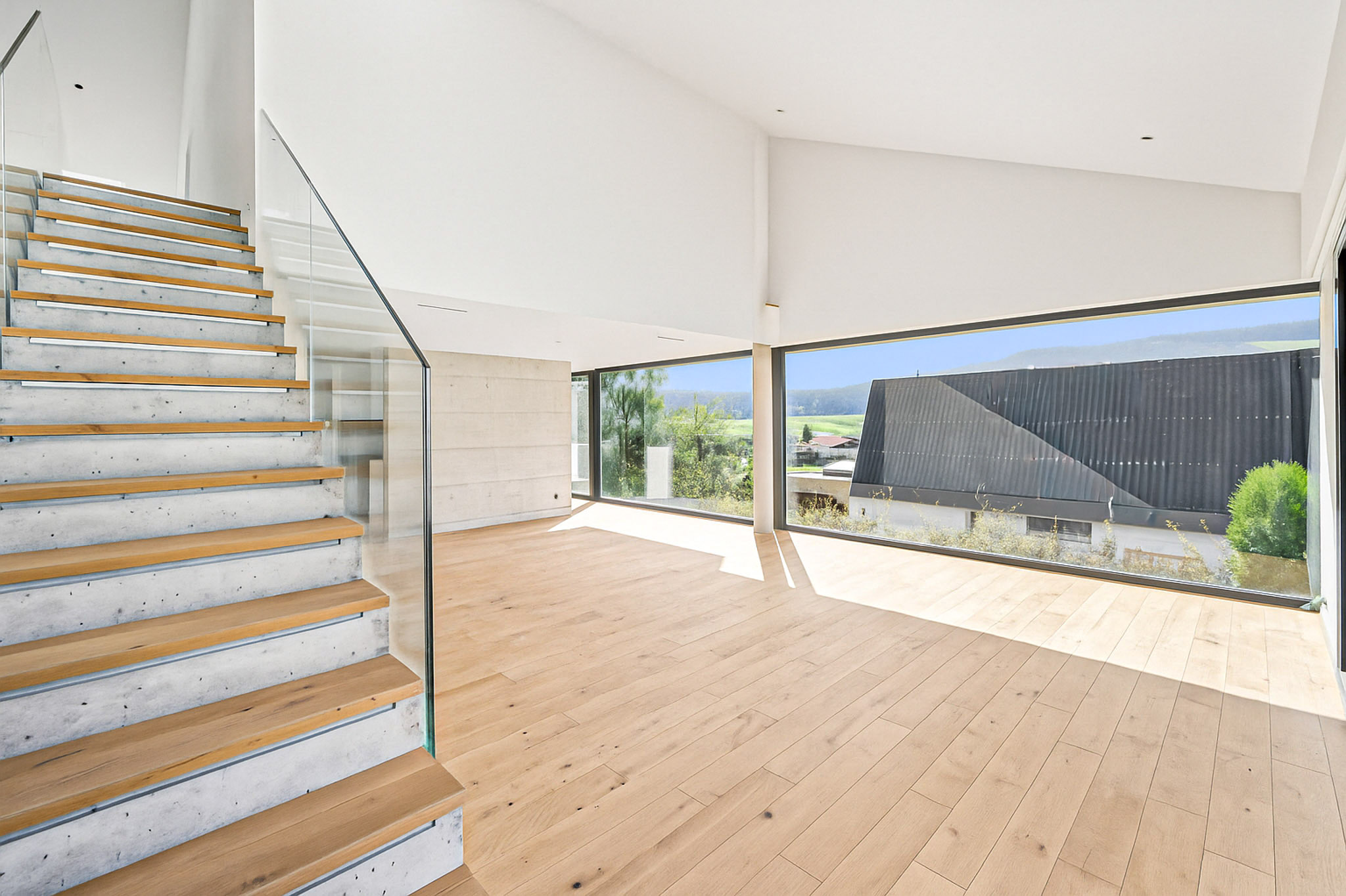 Heller Wohnraum mit Treppe und Panoramafenstern