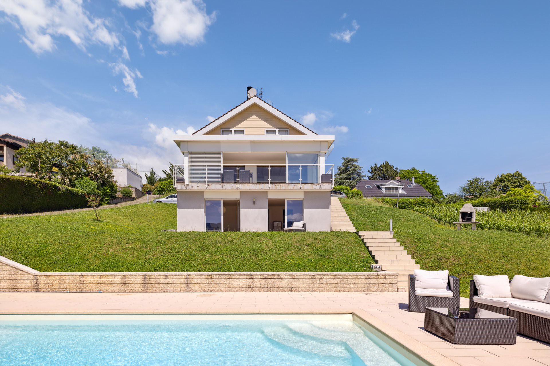 Außenansicht eines Einfamilienhauses mit Pool und Garten