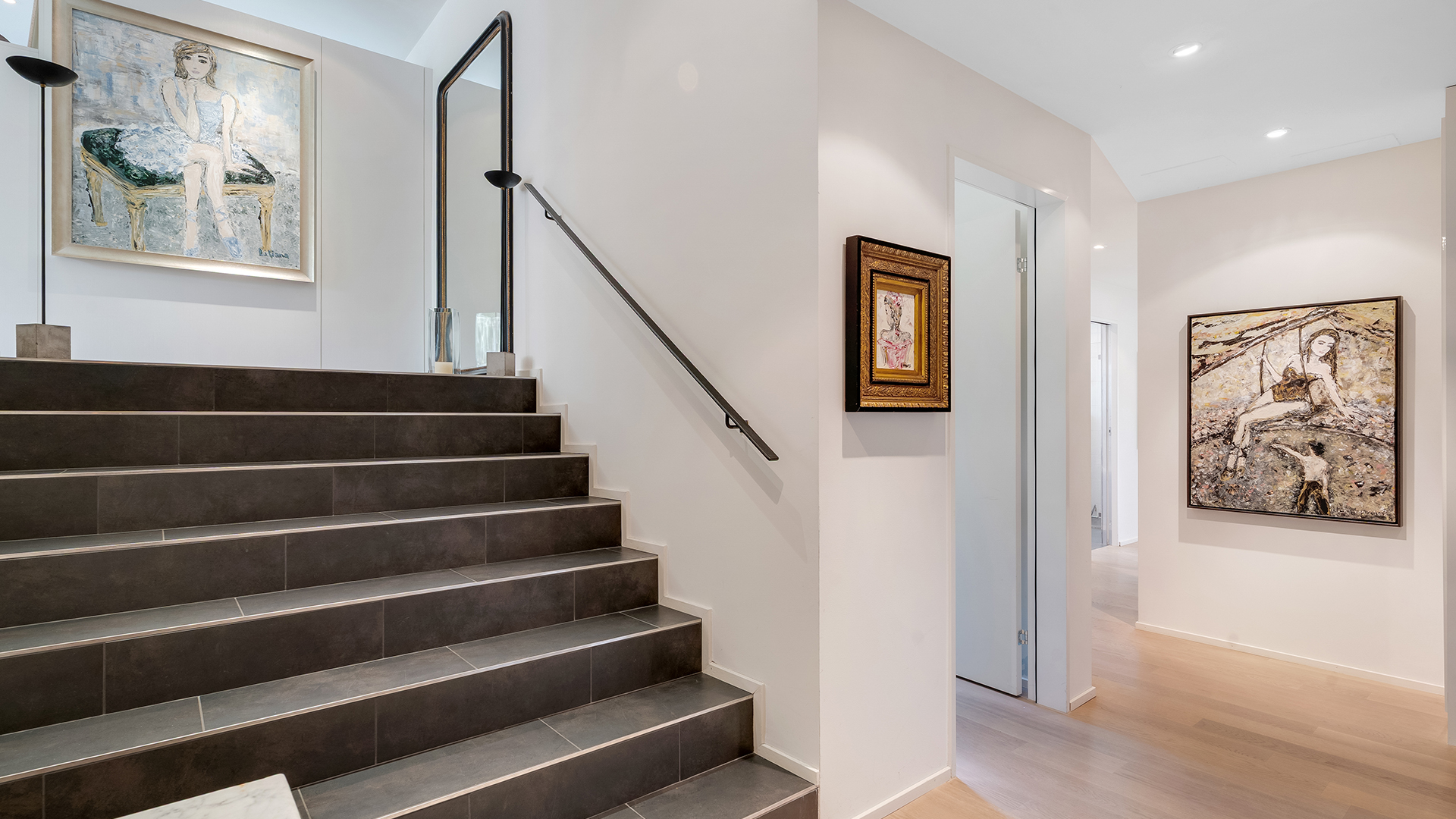 Heller Eingangsbereich mit Treppe und Kunstwerken