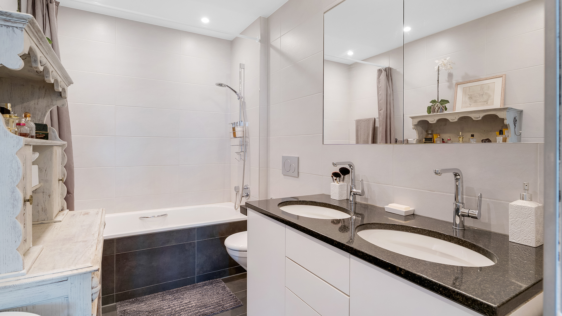 Helles Badezimmer mit Doppelwaschtisch und Badewanne
