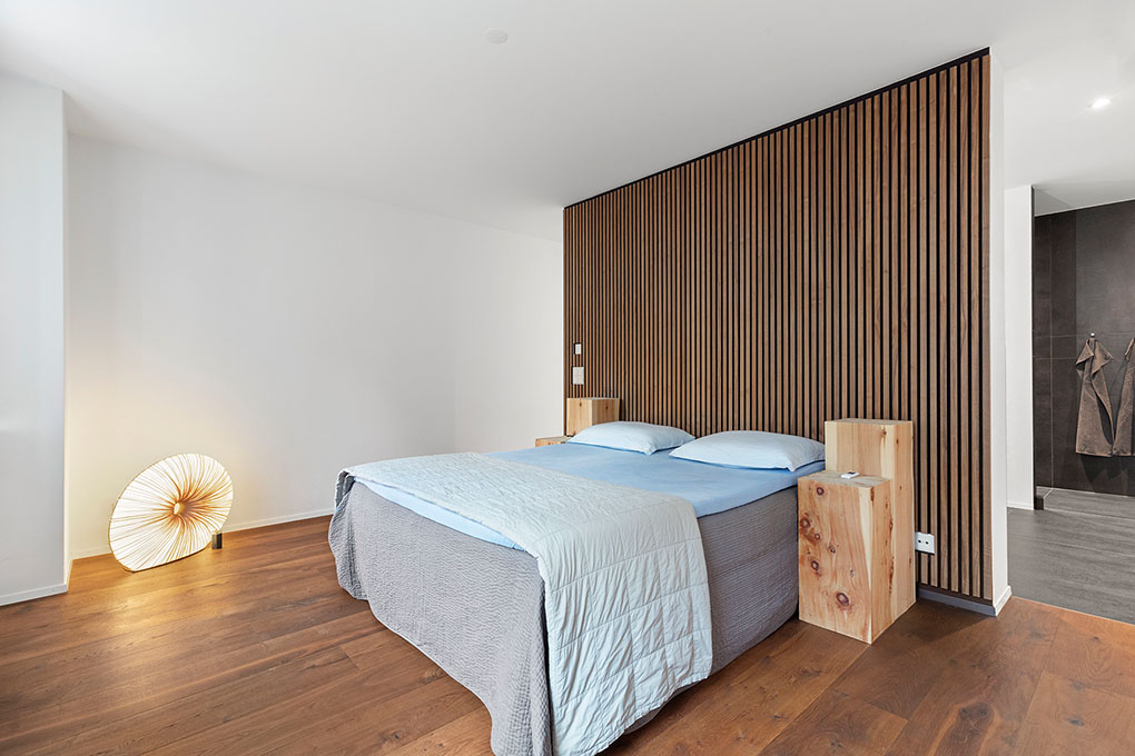 Modernes Schlafzimmer mit Akzentwand aus Holzlamellen