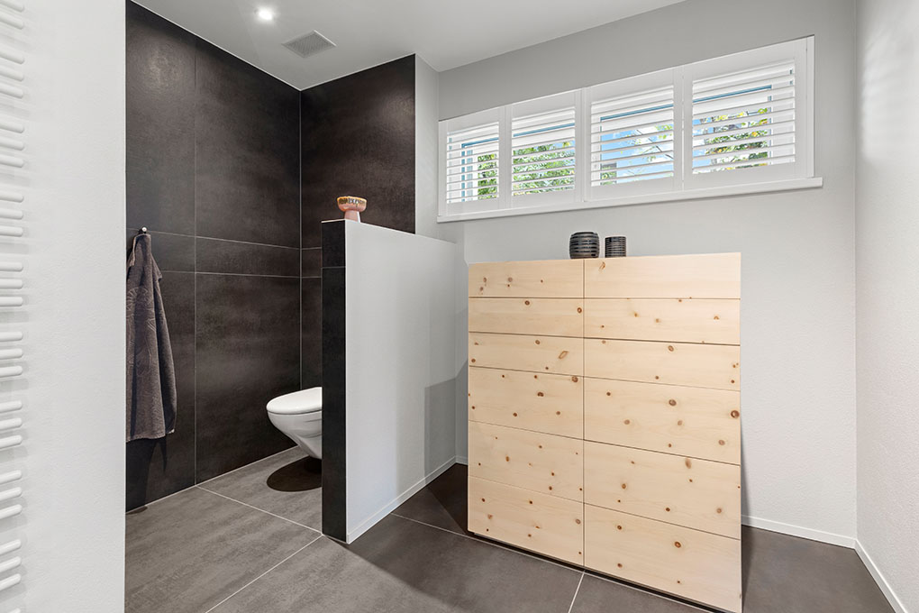 Modernes Gäste-WC mit Holzschrank und dunkler Dusche/Nische