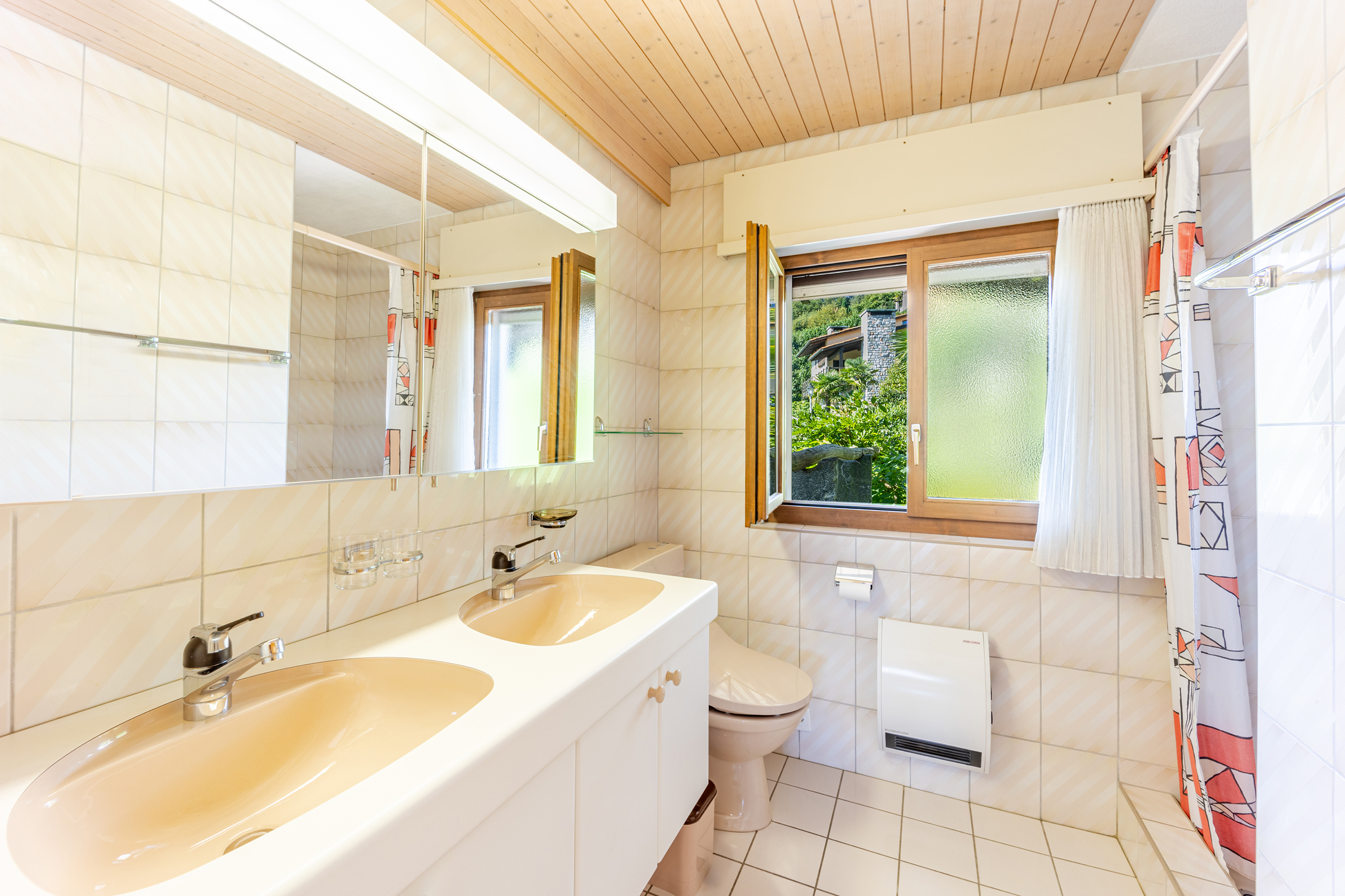 Helles Badezimmer mit Doppelwaschtisch und Fensterblick
