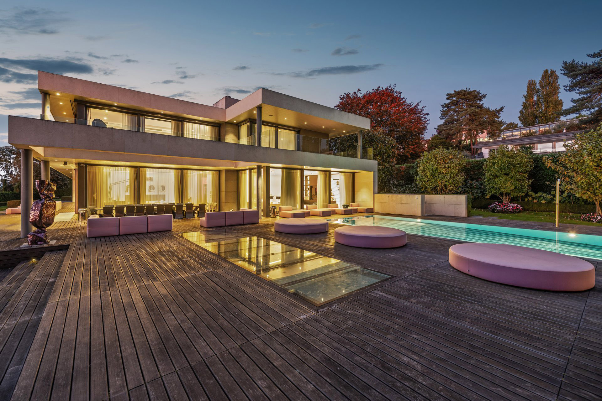 Luxuriöse moderne Außenansicht mit Poolterrasse bei Dämmerung