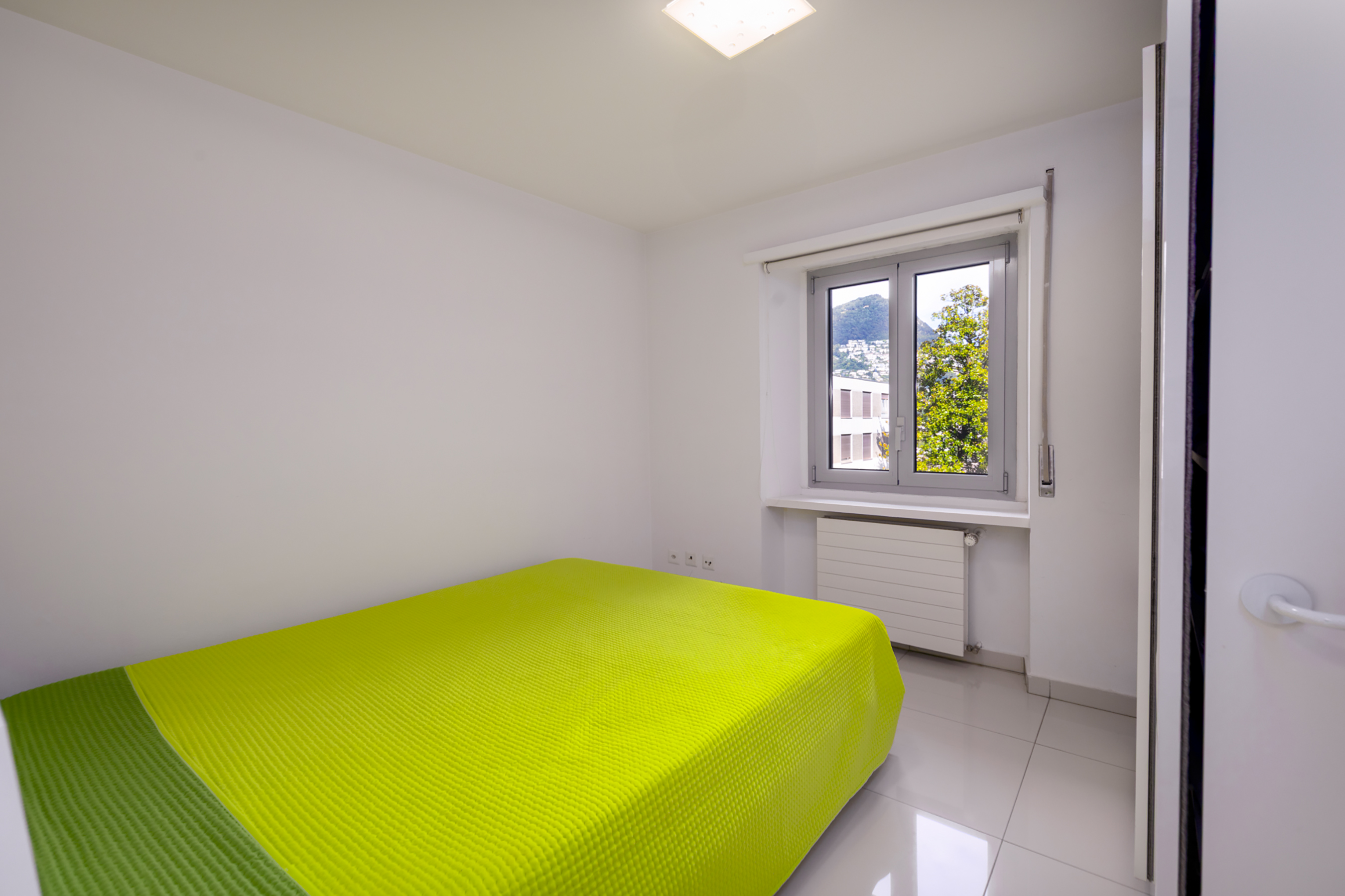 Helles Schlafzimmer mit grünem Bett