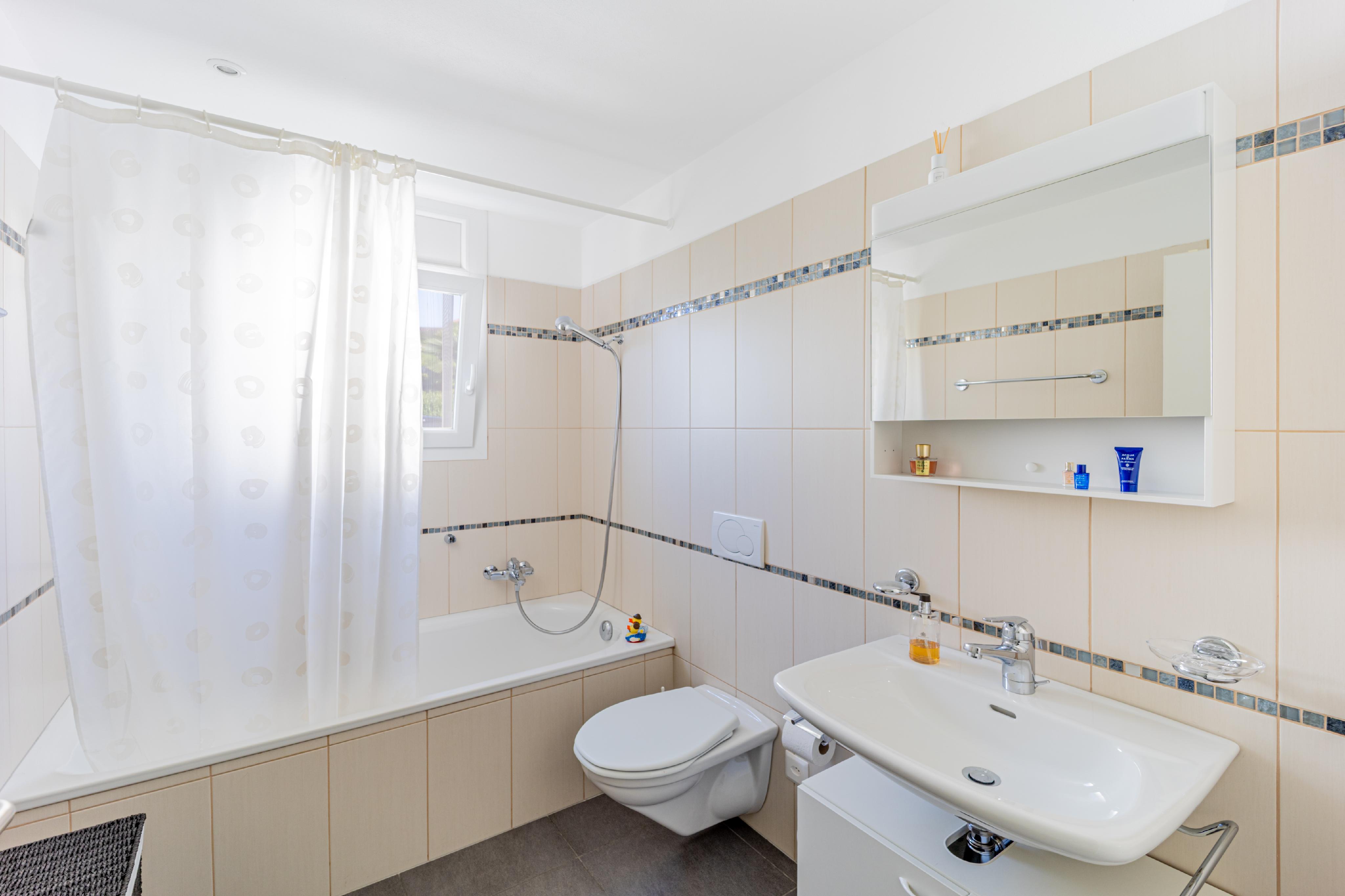 Helles Badezimmer mit Wanne, Waschbecken und WC