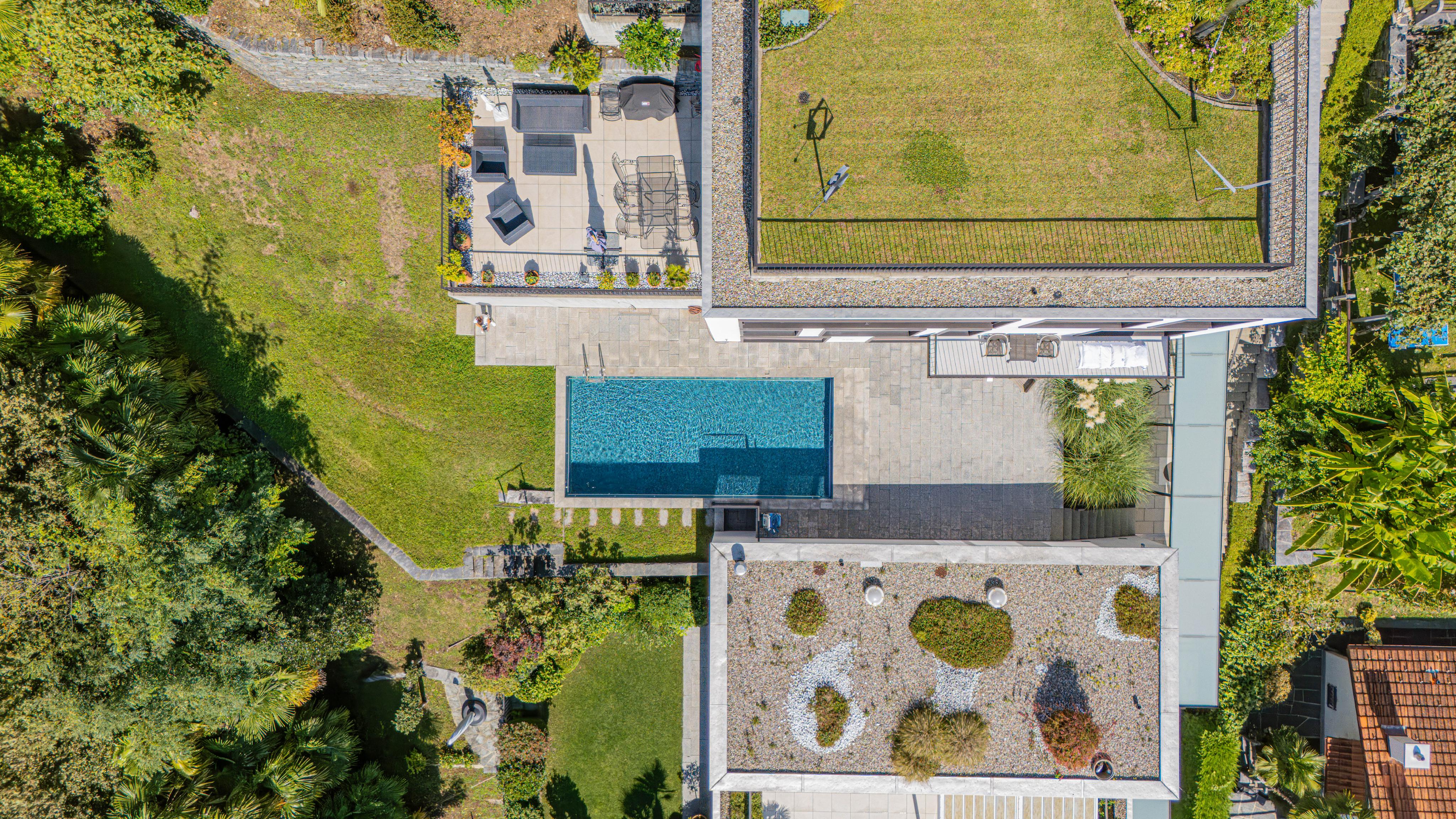 Luftaufnahme eines modernen Anwesens mit Pool und Dachterrassen