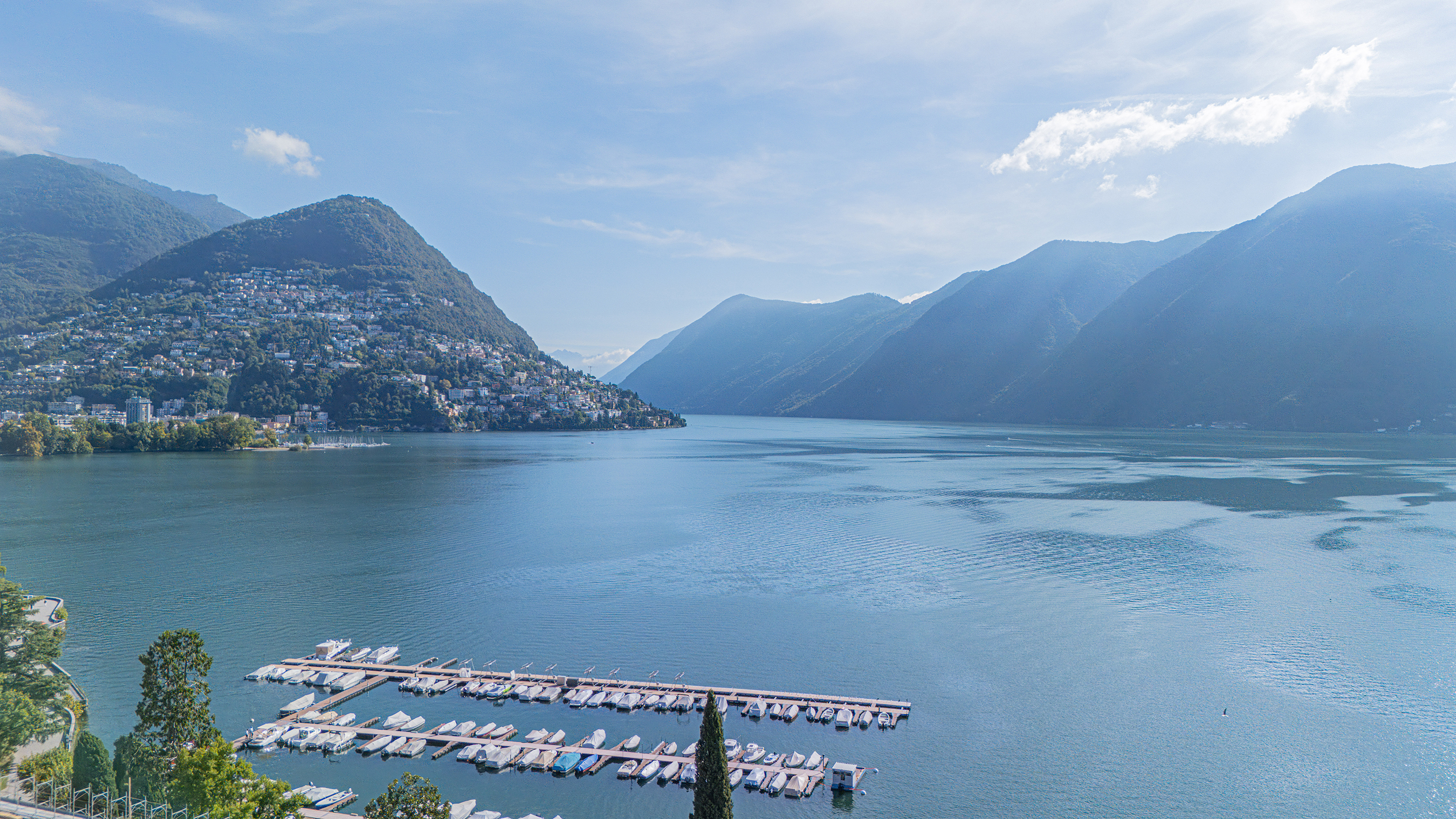 Seeblick mit Bergen und Yachthafen