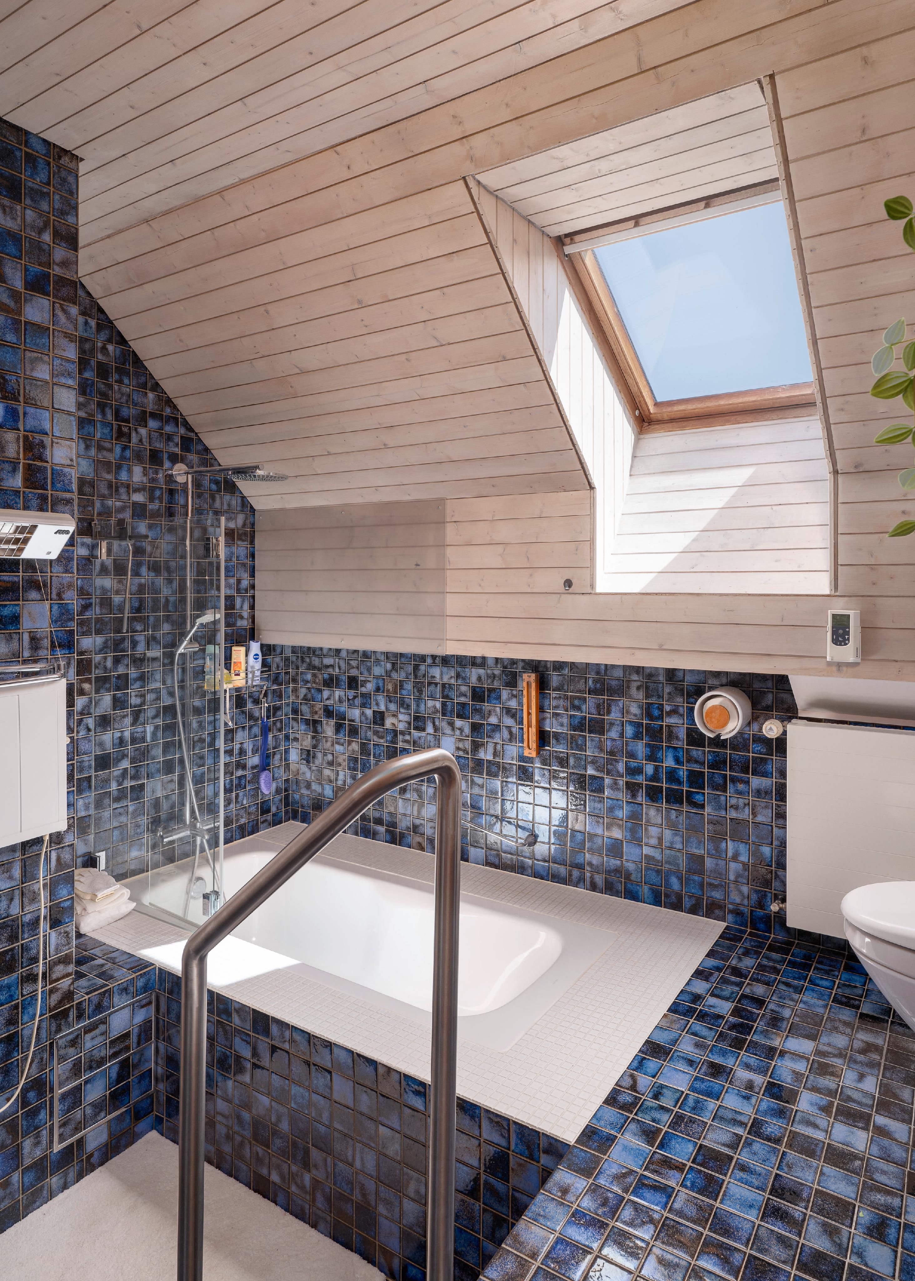 Badezimmer mit Dachfenster und blauen Mosaikfliesen