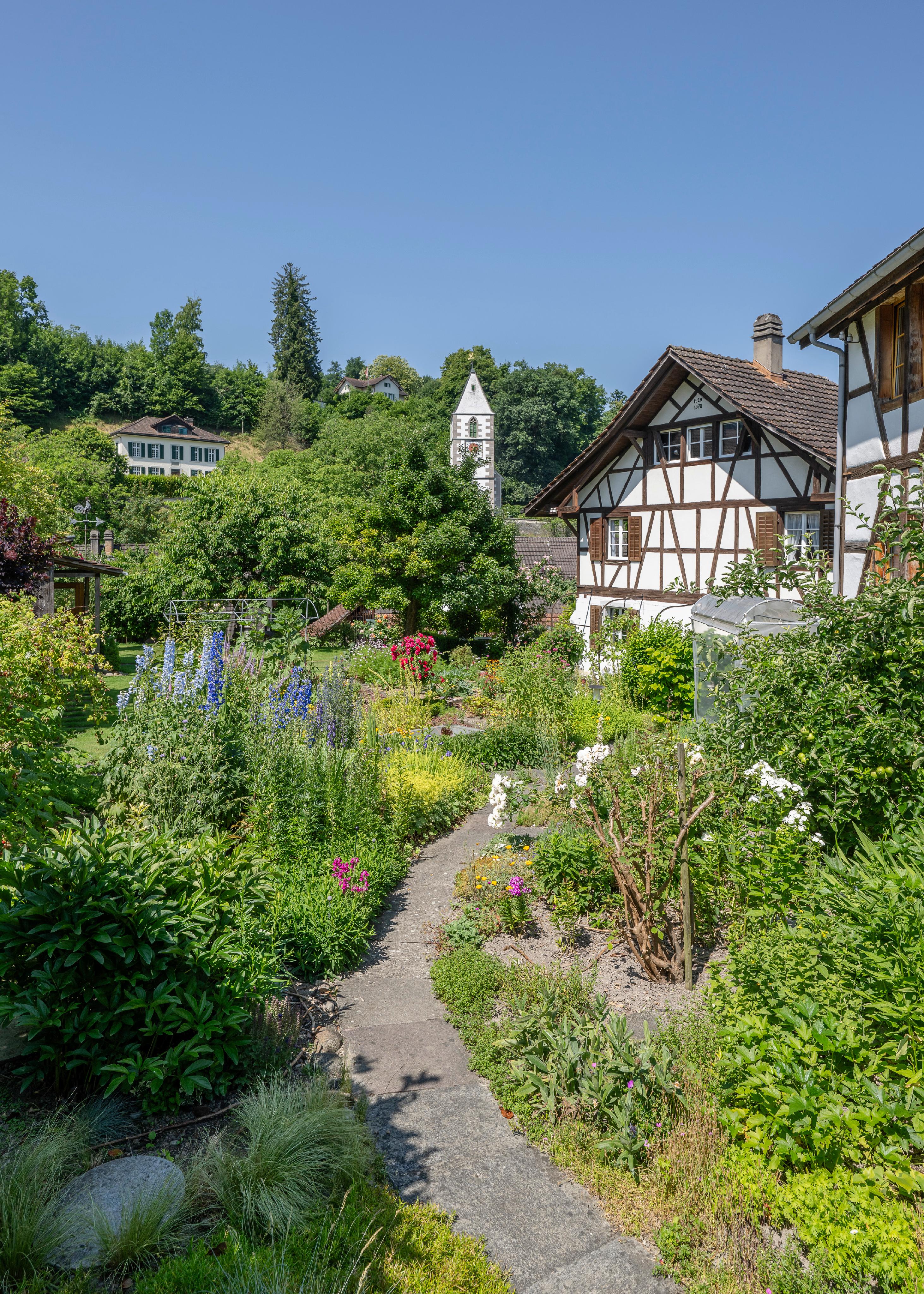 Üppiger Garten mit Fachwerkhäusern
