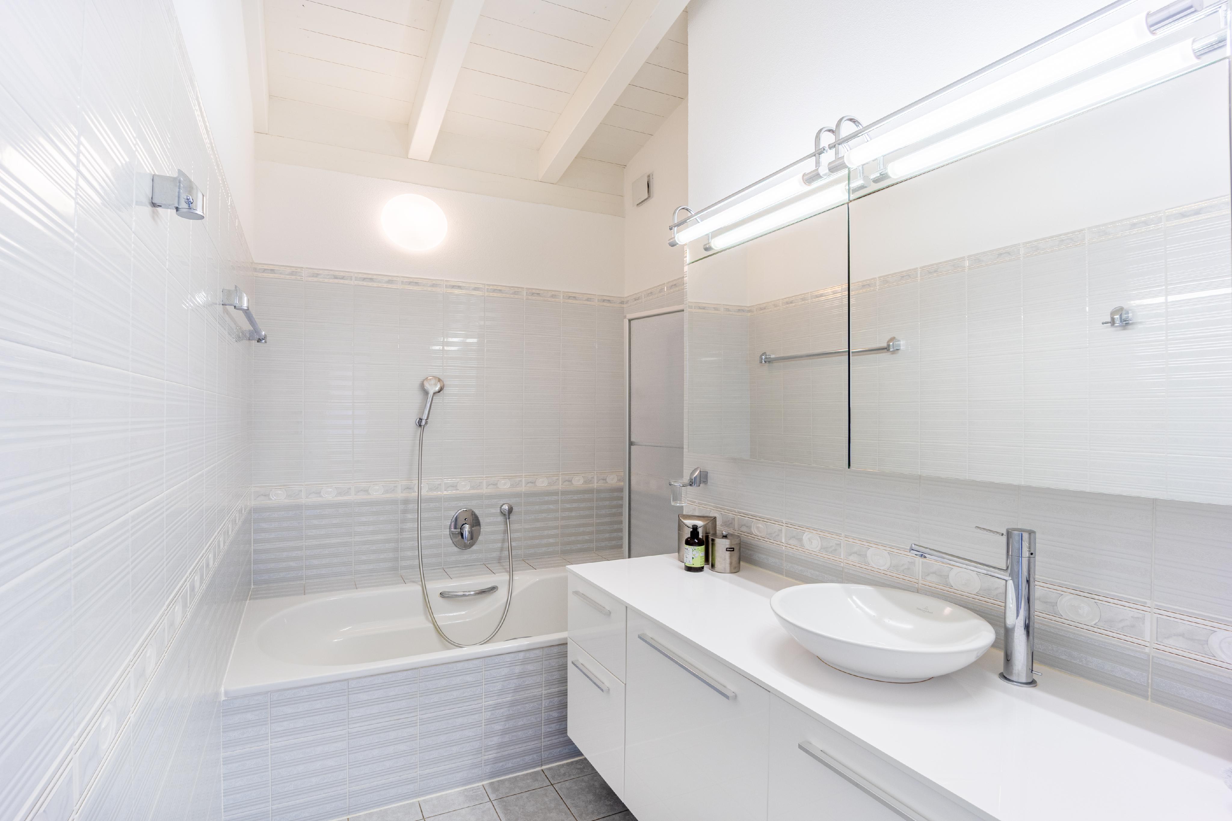 Helles Badezimmer mit Wanne und Waschtisch