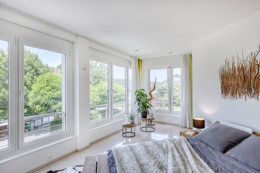 Helles Schlafzimmer mit großen Fenstern