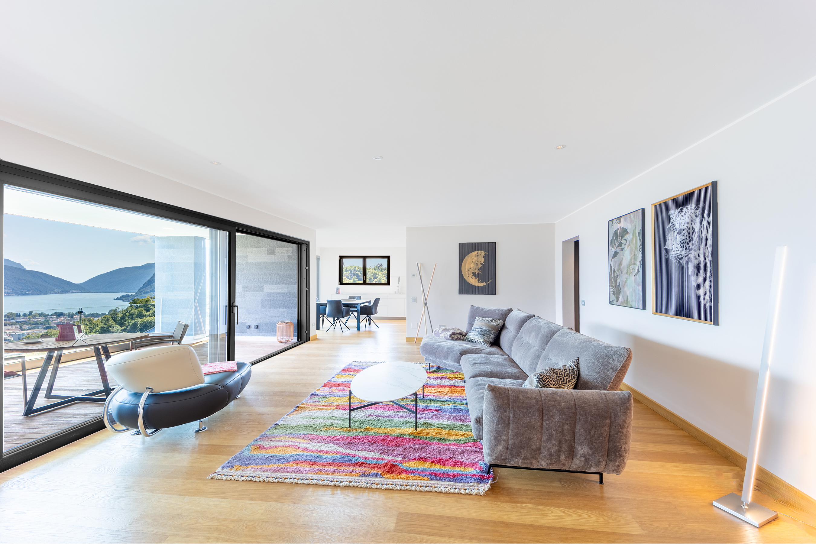 Helles Wohnzimmer mit Seeblick und offener Fensterfront